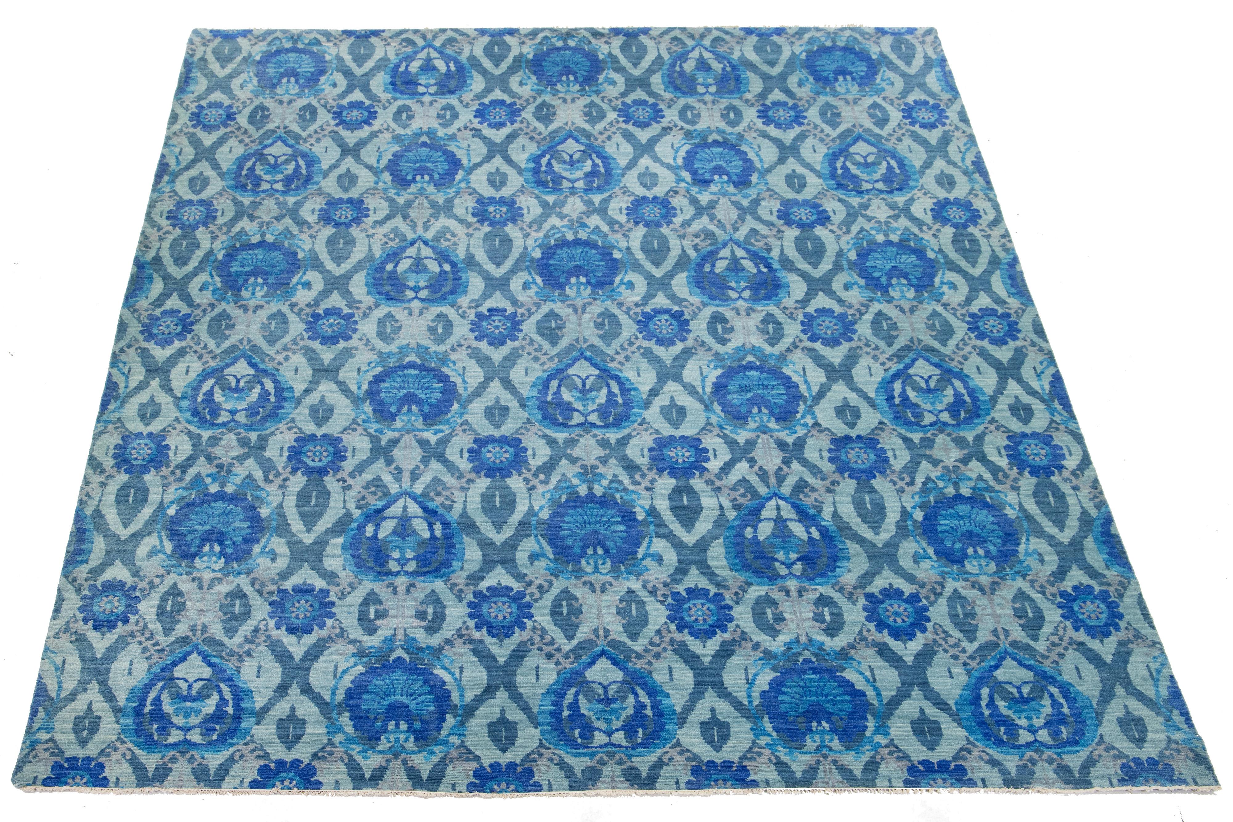 Questo bellissimo tappeto Ikat è annodato a mano in lana e presenta una splendida combinazione di colori verde e blu. Il suo motivo geometrico all-over è accentuato da eleganti tonalità di grigio chiaro, che lo rendono un'aggiunta perfetta a