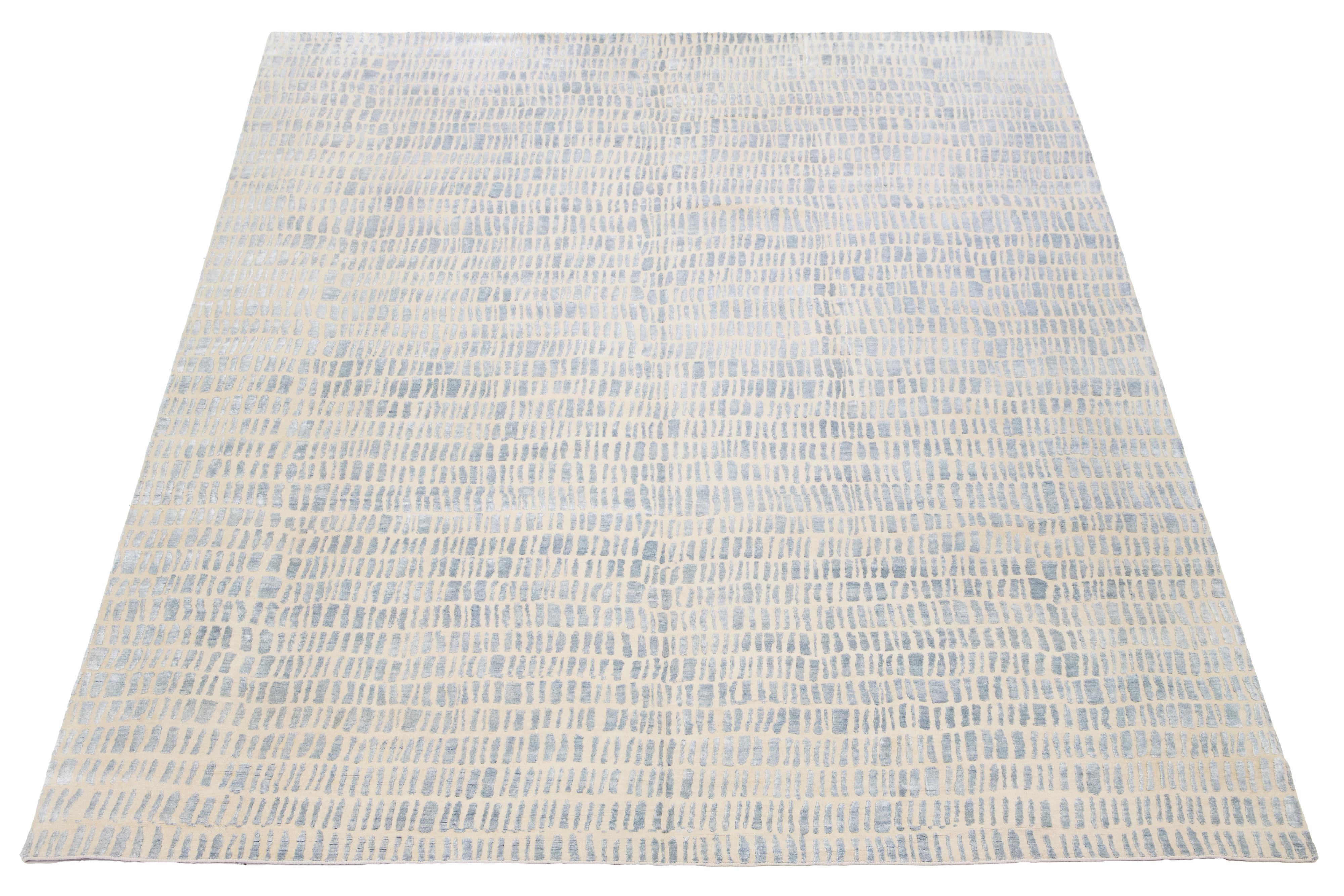 Esta alfombra contemporánea anudada a mano presenta un impresionante diseño geométrico en colores vibrantes que capta la atención sin esfuerzo. Fabricado con lana o seda de alta calidad, tiene un fondo beige que realza los intrincados detalles del