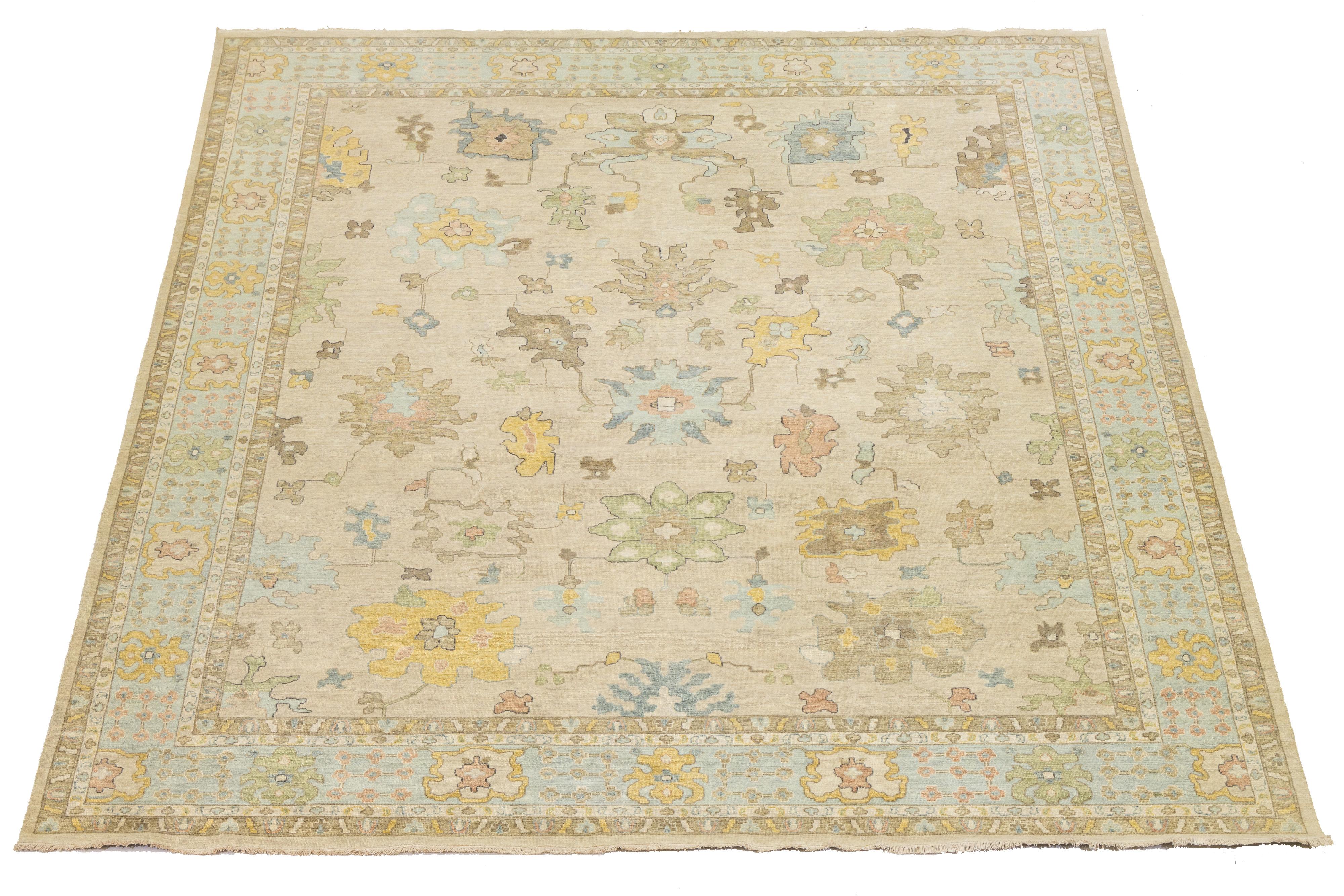 Ce tapis moderne en laine nouée à la main, de style Oushak, allie admirablement l'esthétique contemporaine au charme durable de l'artisanat traditionnel Oushak. Doté d'un riche fond brun, il est orné de motifs floraux vibrants qui créent une