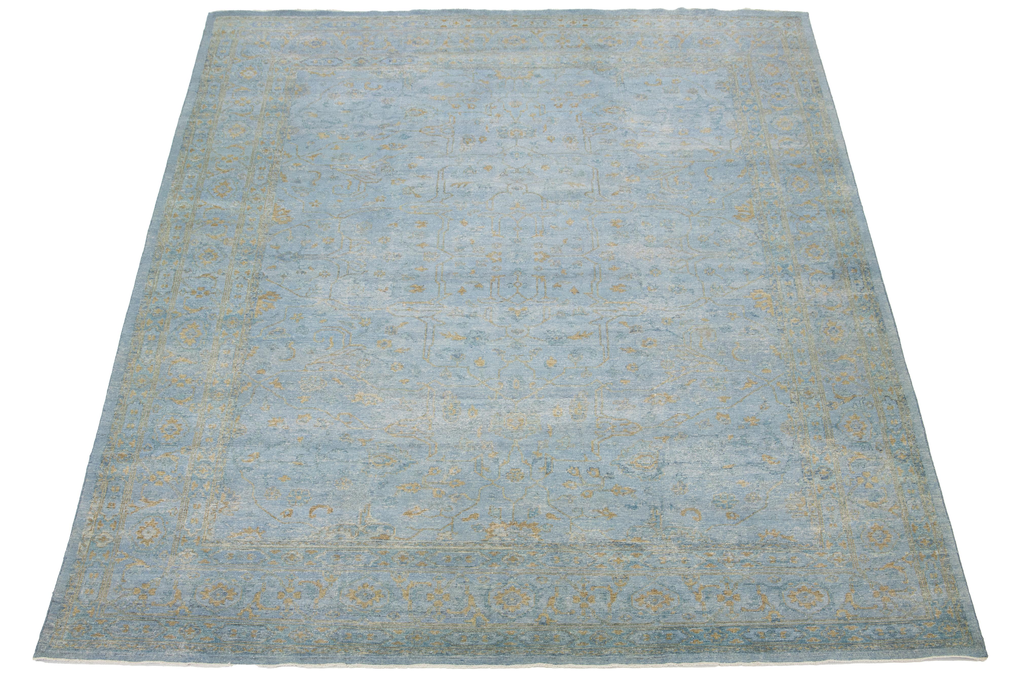Ce tapis Oushak est noué à la main avec un champ bleu. Ce tapis de style moderne du milieu du siècle est orné d'un motif floral doré. 

Ce tapis mesure 11'9