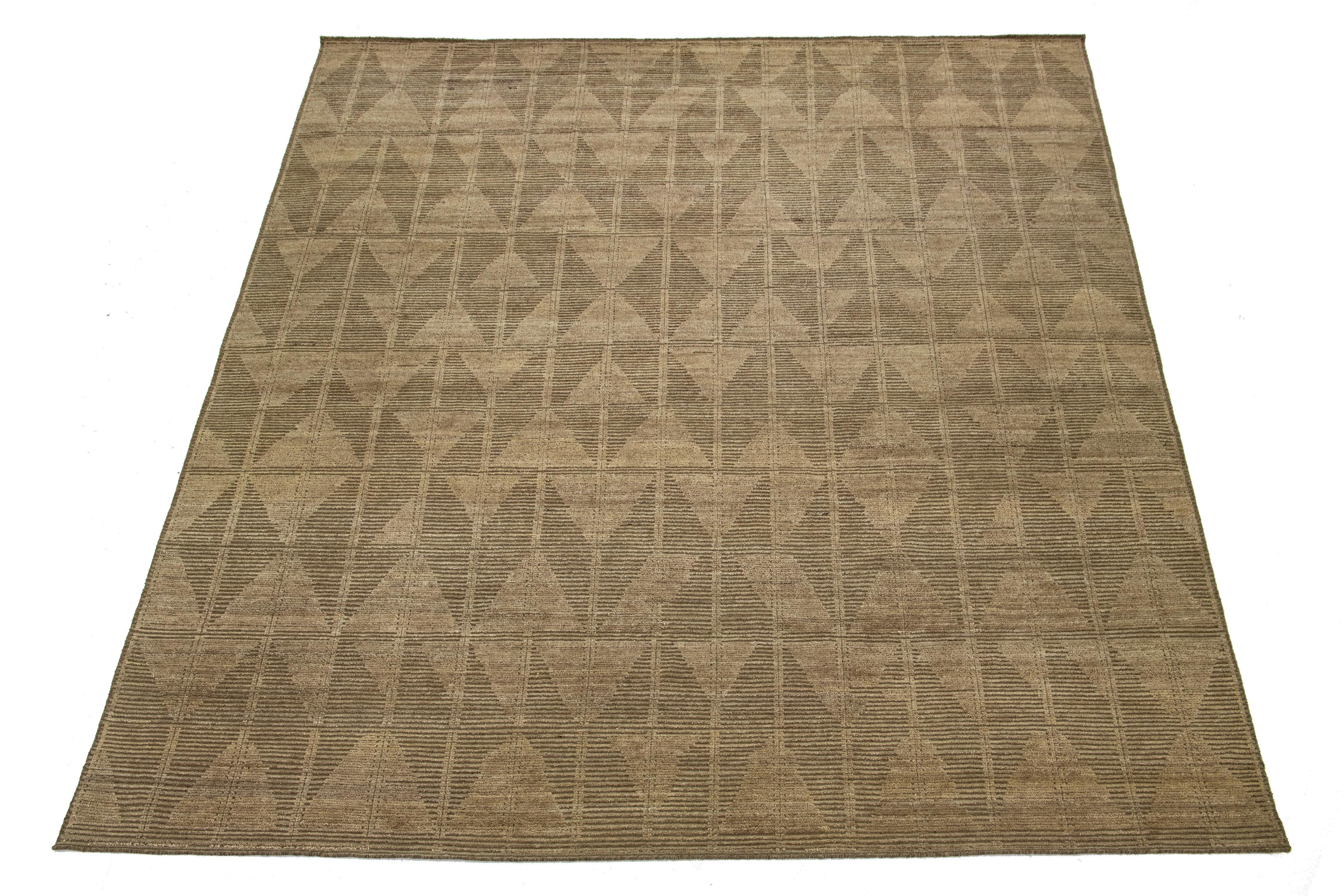 Ce superbe tapis en laine marocaine noué à la main met brillamment en valeur un riche champ de couleur marron orné d'un motif géométrique saisissant. Ce tapis est une pièce maîtresse captivante pour tout espace.

Ce tapis mesure 12'2