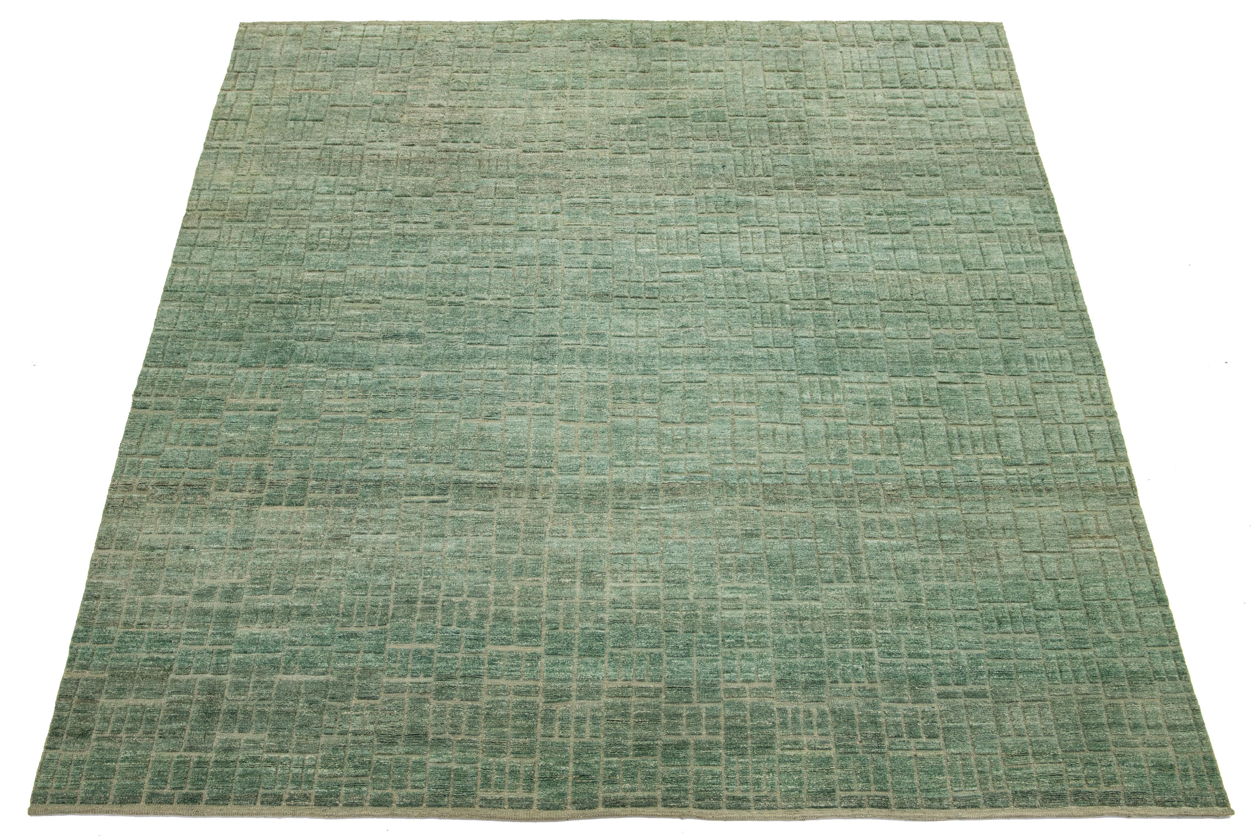 This 12 x 15 hand-knotted organic Moroccan wool rug commands attention with its vibrant green background, beautifully complemented by beige accents and striking geometric designs. 

This rug measures 12'2