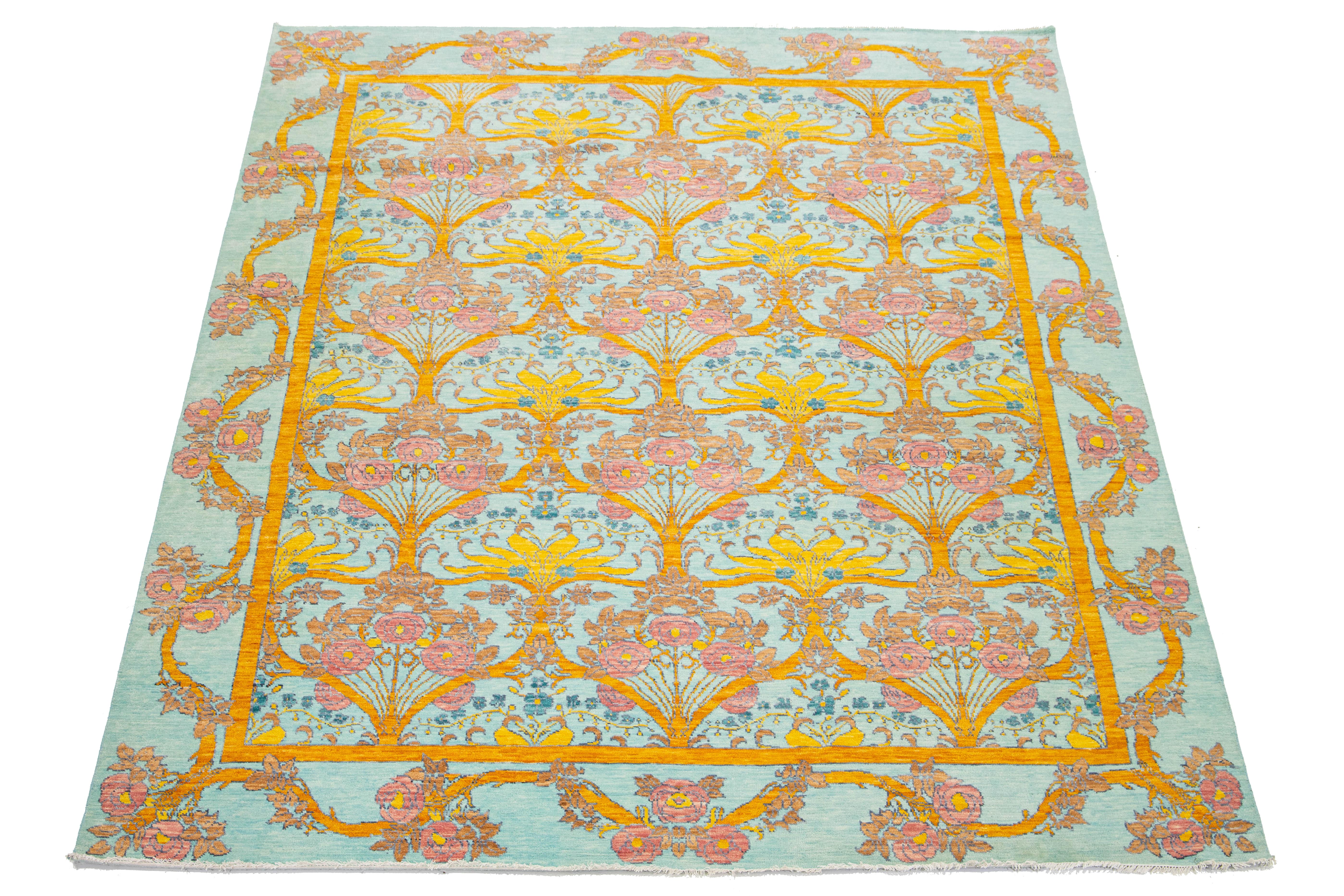 Esta moderna alfombra de lana estilo Oushak presenta un giro contemporáneo a los diseños tradicionales de Oushak. La impresionante pieza presenta un suave fondo azul pálido, bellamente acentuado por vibrantes motivos florales en tonos rosa, marrón y