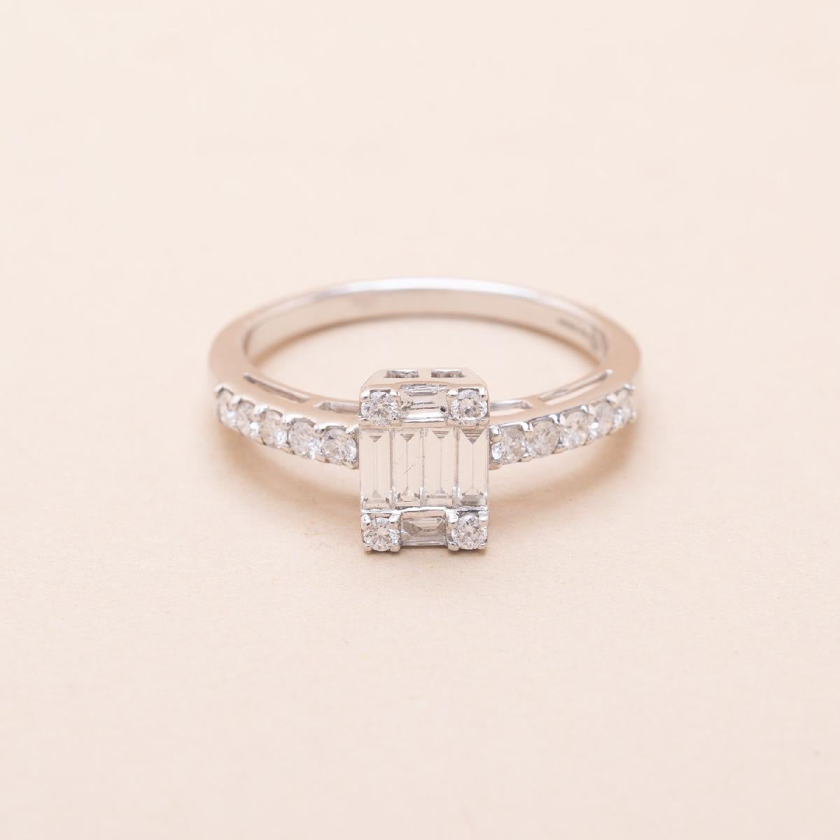 18K white gold baguette and round brilliant cut diamonds. 1.20 carat total. 
Estimated diamonds characteristics : Color F, Purity VVS, fluorescence none to faint.

French creation from the 2000s, never worn

The stones on the bezel gives the