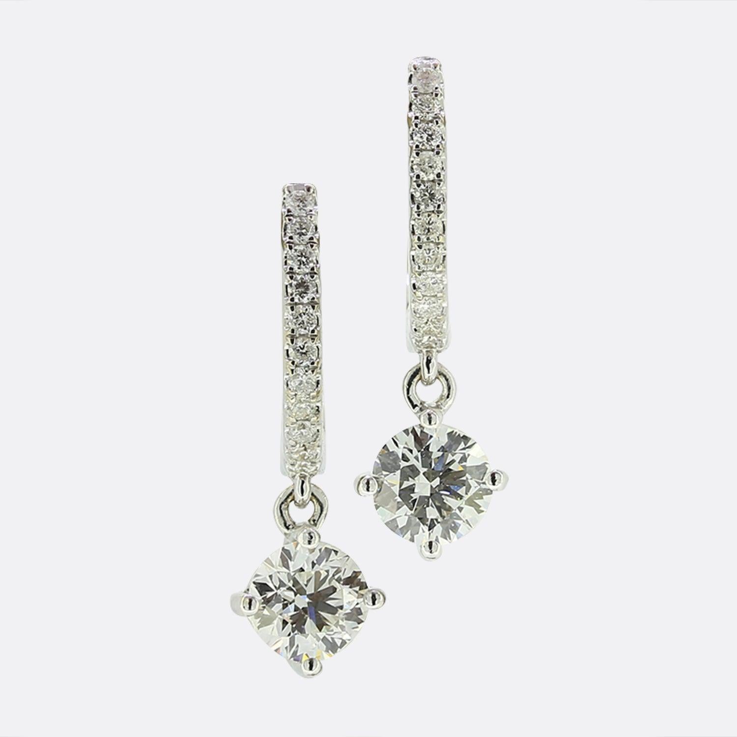 Dies ist ein Paar zeitgenössischer Diamant-Ohrringe aus 18 Karat Weißgold. An jedem Ohrring hängt ein runder Diamant mit Brillantschliff, der von diamantbesetzten Reifen aus 18 Karat Weißgold getragen wird. Die Diamanten sind in Farbe und Reinheit