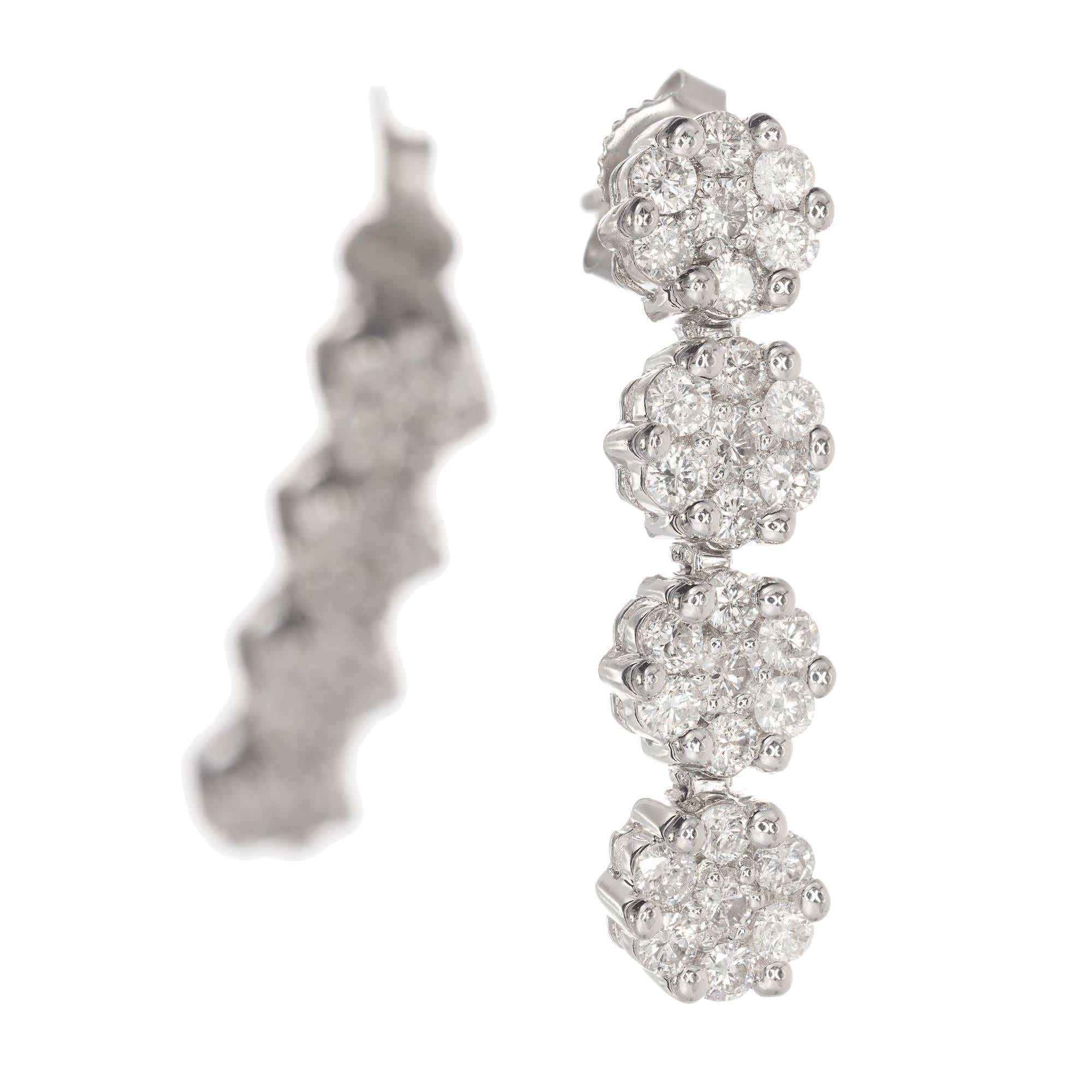14k white gold diamond cluster drop dangle earrings. Four clusters of round brilliant cut diamonds dangle form each other to create these drop earrings.

56 round brilliant cut H-I SI diamonds 1.8-2.0mm Approximate 1.20 total carat weight
14k White