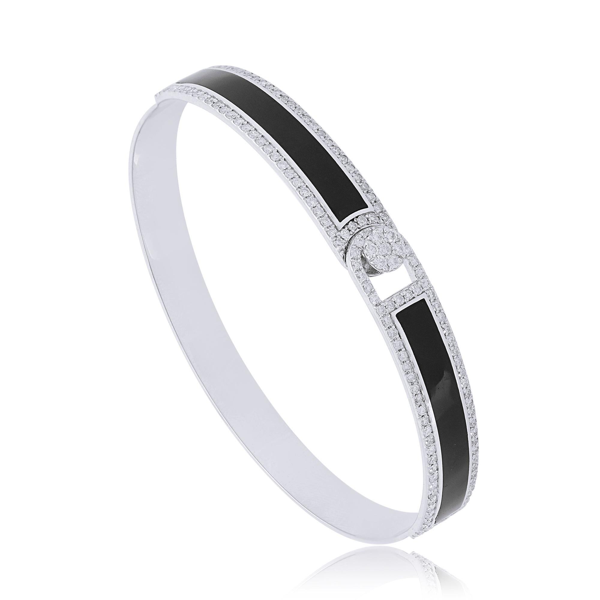 The bangle itself is meticulously crafted from high-quality 14k white gold, renowned for its durability and radiant shine. The smooth, polished surface of the gold complements the bold contrast of the black enamel and the brilliance of the diamond,