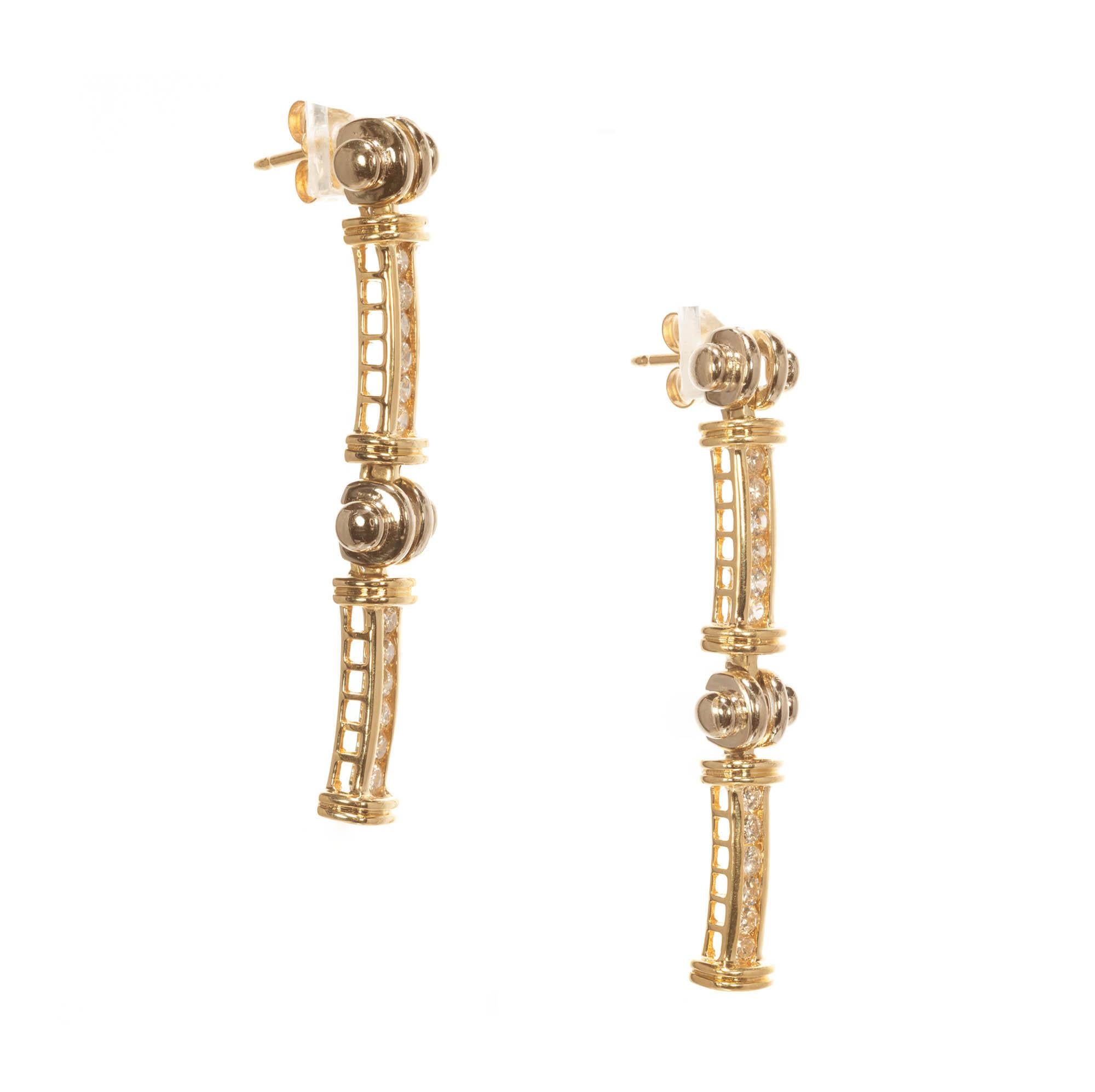 14k Two tone gold diamond drop earrings. Two yellow gold channel set bars suspended and linked together by a white gold bar bell.

24 round SI diamonds 1.20 carat total weight
14k Yellow Gold
14k White Gold 
Tested: 14k
Stamped: 585
8.9 Grams
Top to