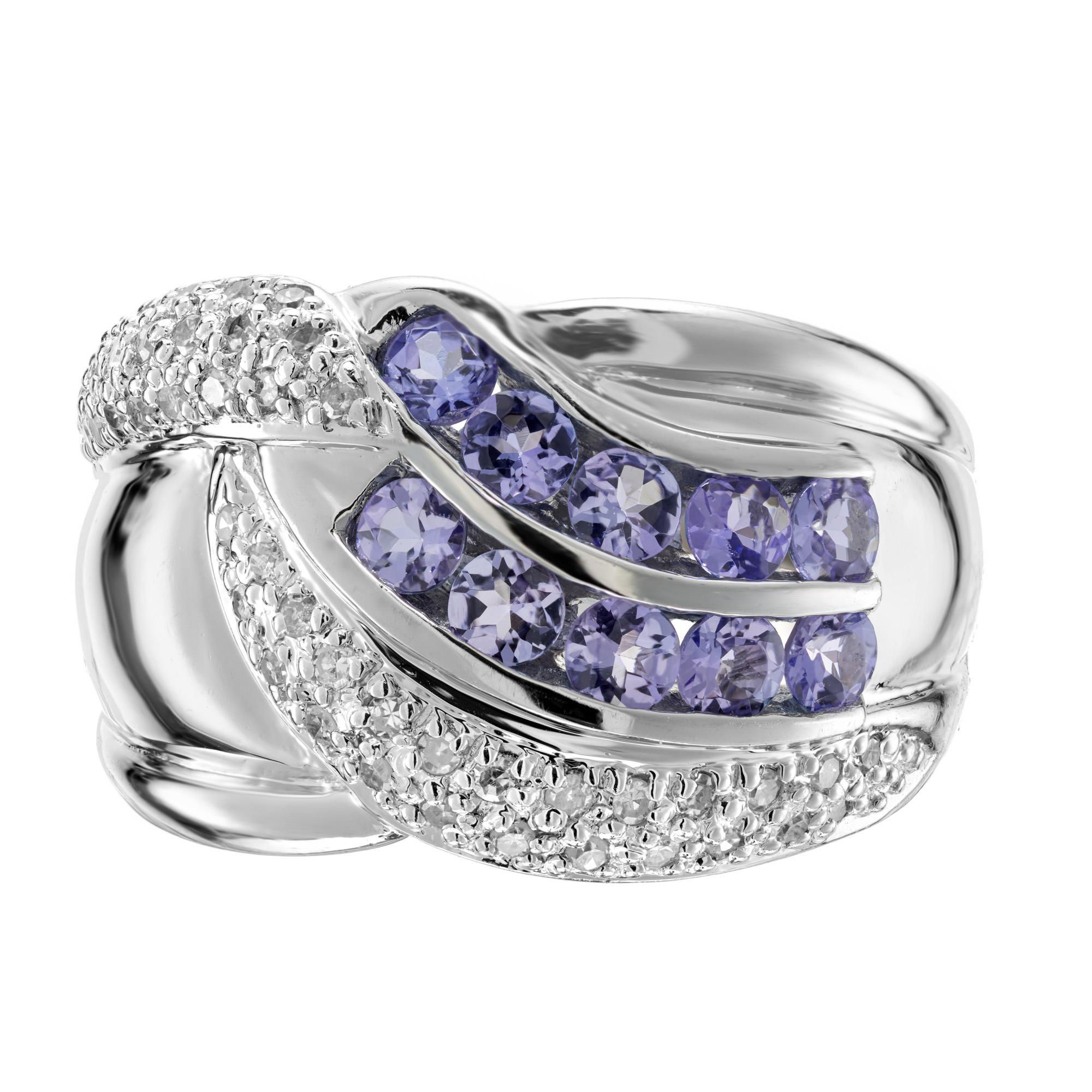 1990's Tanzanite and diamond cocktail band ring. 10 round cut purple tanzanite gemstones totaling 1.20cts, mounted in two rows and accented with 44 round pave set diamonds. At its widest point, this ring is a little over .56 inches across the top.