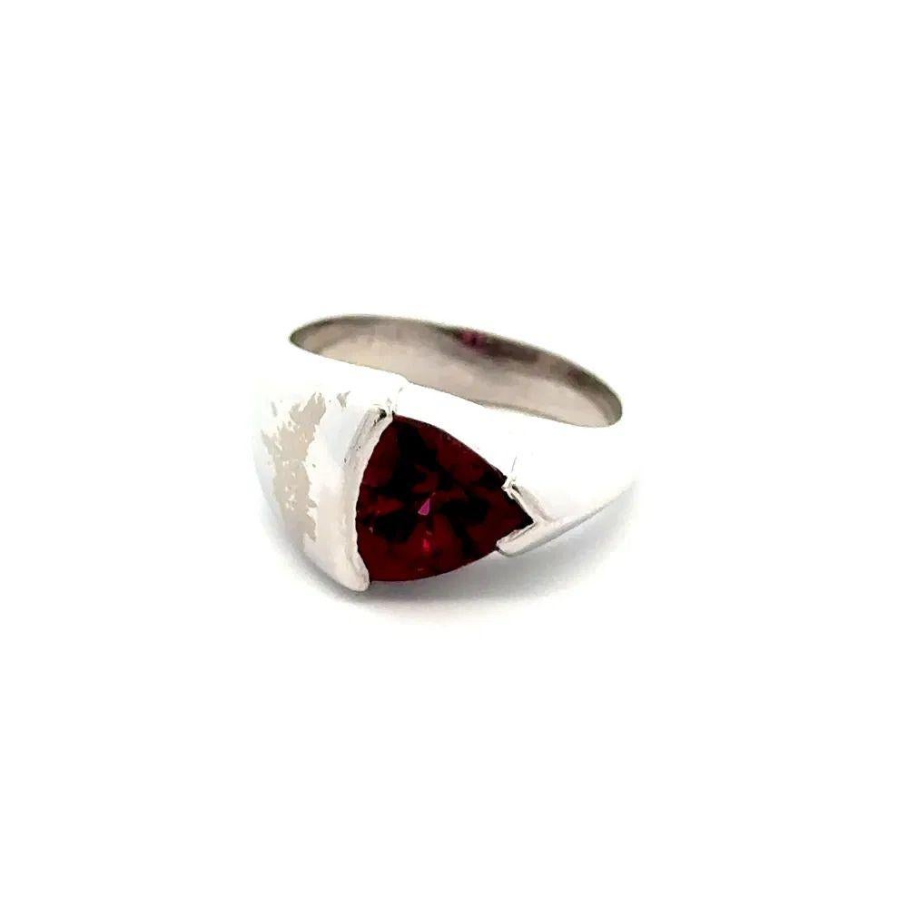 Simply Beautiful! Elegant and finely detailed Red Trillion Rhodolite Garnet Gold Ring. Centering a securely Hand set Red Trillion Rhodolite Garnet, weighing approx. 1.20 Carat. Ring measures approx. 0.30” L x 0.70” W. Hand crafted 18K White Gold