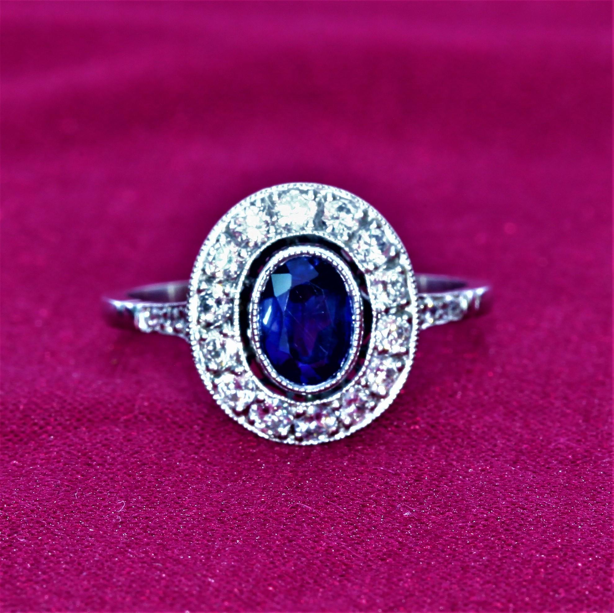 Approximately 1.20 carat sapphire surrounded by a millegrain set halo of diamonds with pave diamonds down the shank set in platinum. Gross weight is approximately four grams. 