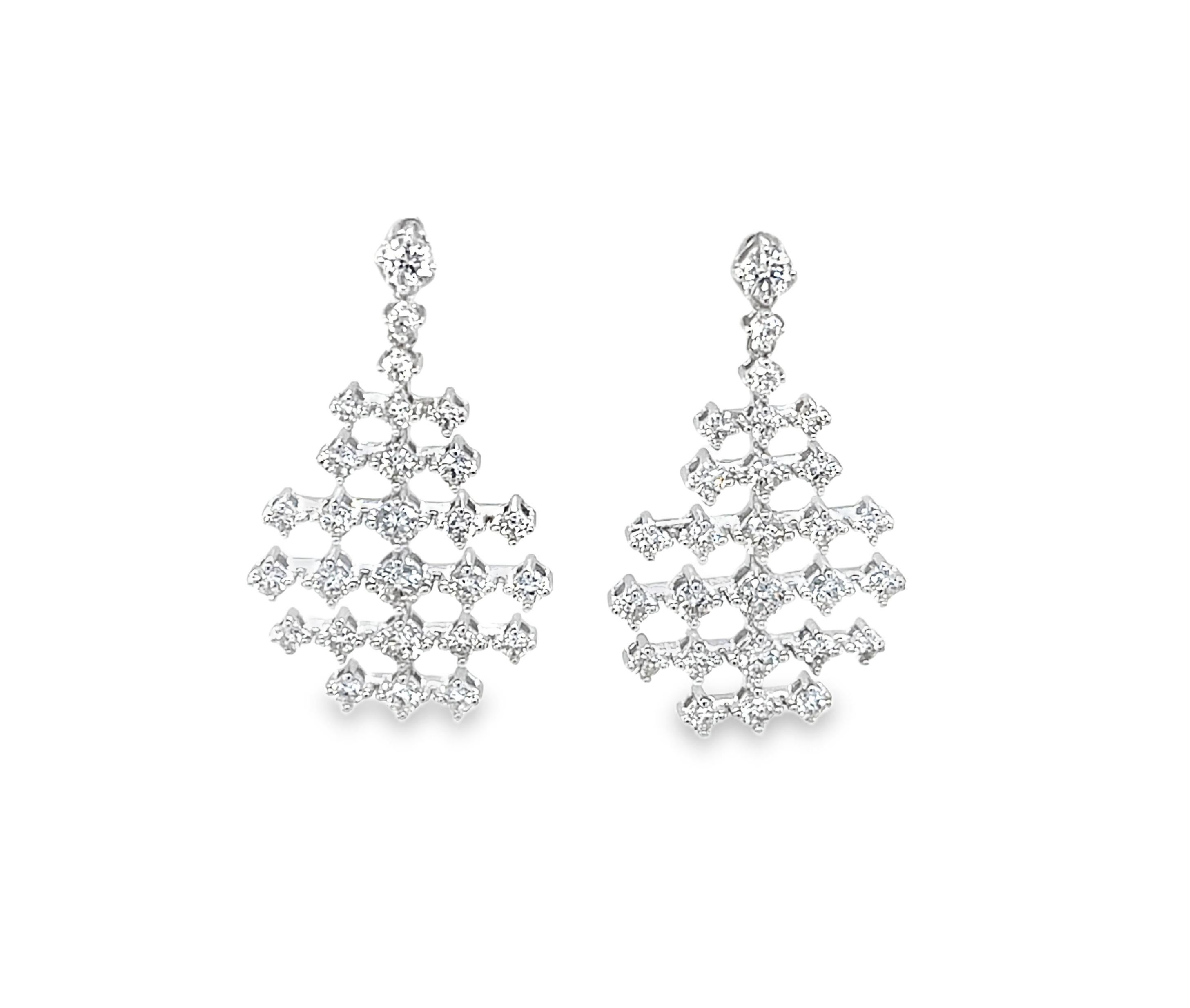 Ces élégantes boucles d'oreilles pendantes présentent 1,20 carats de diamants naturels ronds et brillants sertis dans un magnifique motif géométrique en dentelle d'or blanc 18k. Ils mesurent environ 1