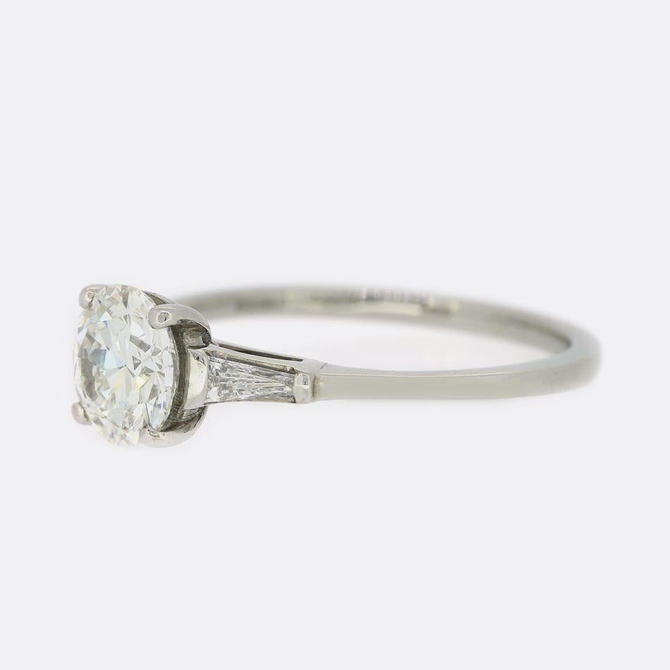 This is a wonderful 18ct white gold diamond solitaire engagement ring. The diamond is an impressive 1.20 carat transitional cut and sits in a raised four clawed mount with tapered baguette cut diamond shoulders.

Condition: Used (Very Good)
Weight:
