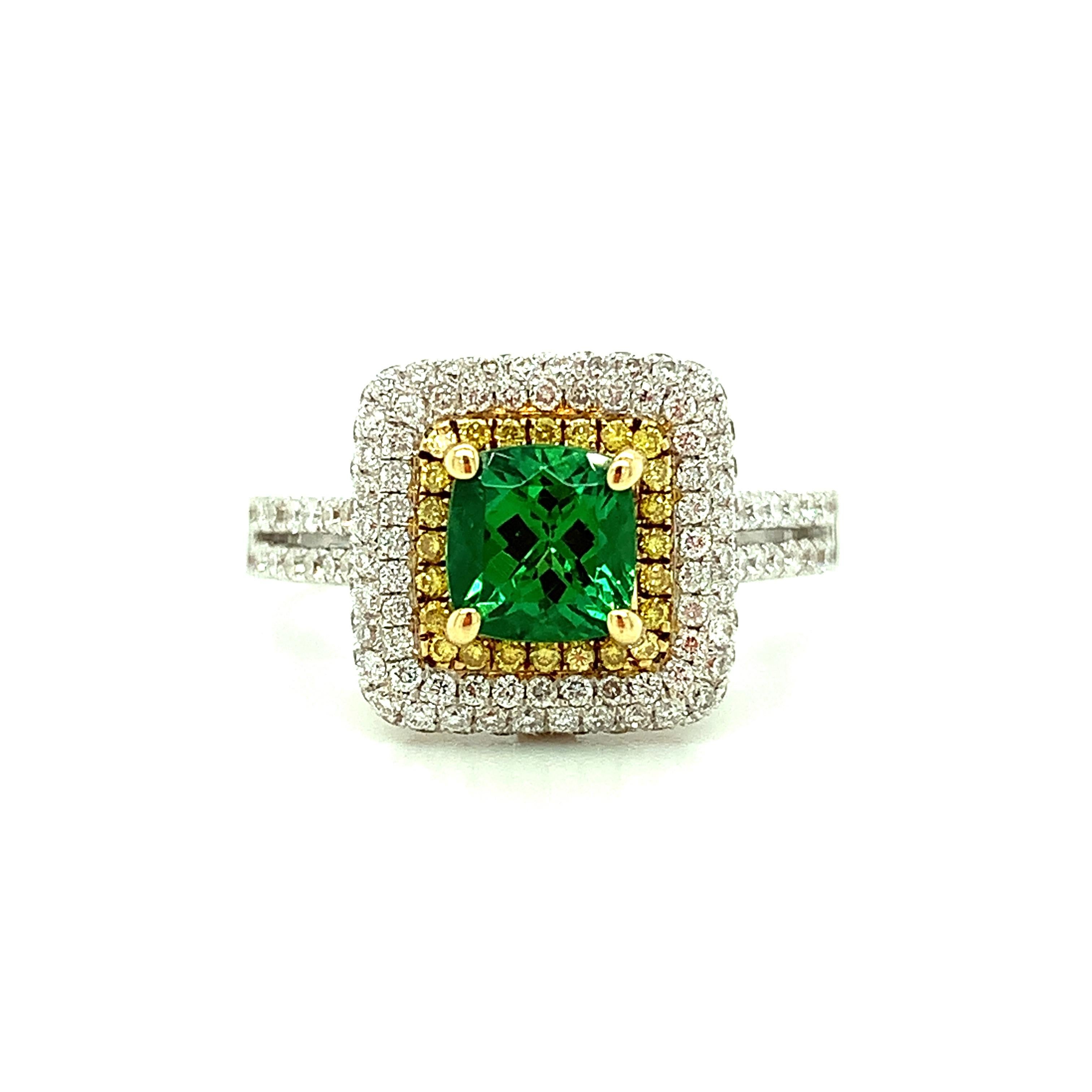 A vibrant, rich green Tsavorite garnet is featured in this gorgeous 18k white gold cocktail ring. The cushion-shaped African tsavorite weighs 1.20 carat and has exceptional color and brilliance. It is surrounded by a halo of bright yellow canary