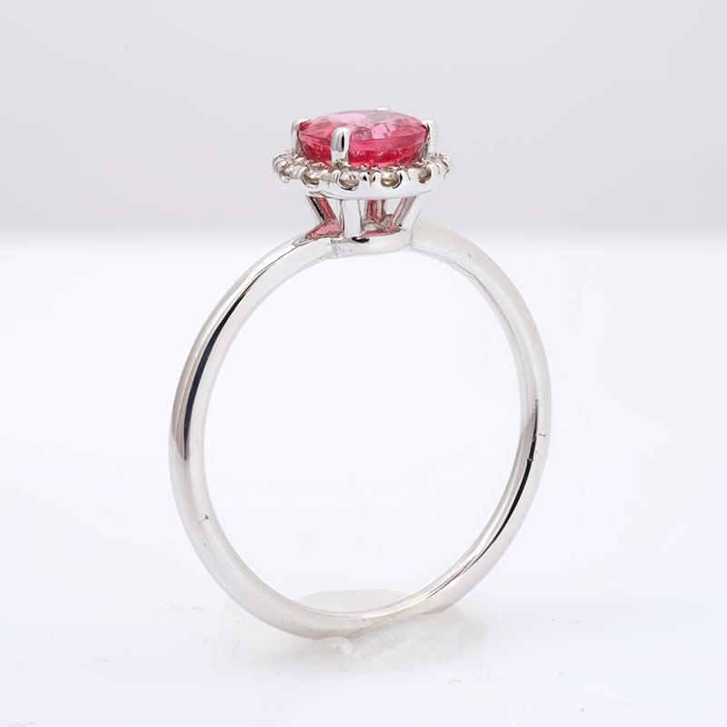 Mined in Tanzania, this round brilliant spinel has an even tone with a beautiful vibrant color. Set at the center of this ring in strong 14K white gold, it will be an ideal ring to pop the big question. The rings chic simplicity will surely have her
