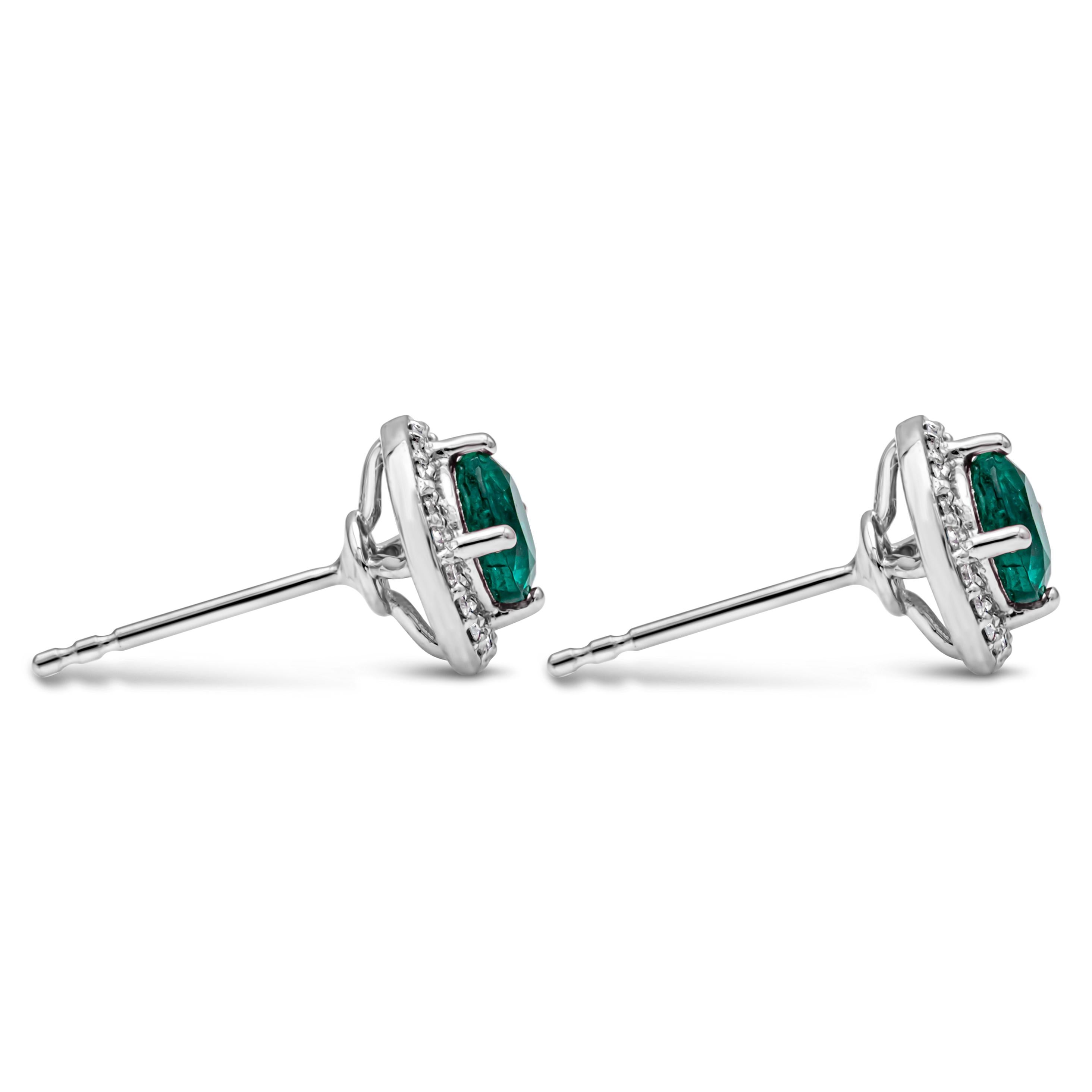 Contemporary 1.20 Carats Total Round Cut Green Emerald and Diamond Halo Stud Earrings For Sale