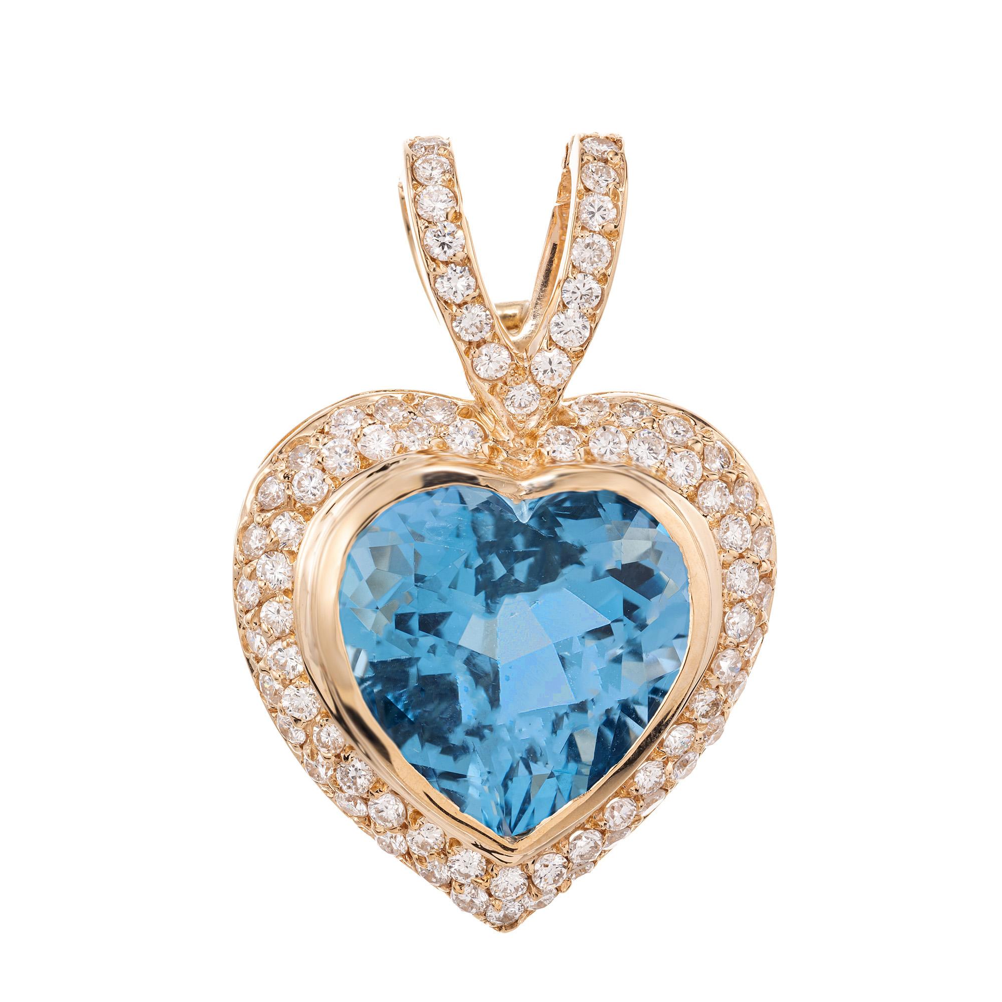 Laissez-vous séduire par l'allure enchanteresse de ce pendentif en forme de cœur en or jaune orné de topazes bleues et de diamants. Cette pièce exquise est sertie d'une topaze bleue vibrante en forme de cœur de 12,00ct. Serti en or jaune 14k d'un