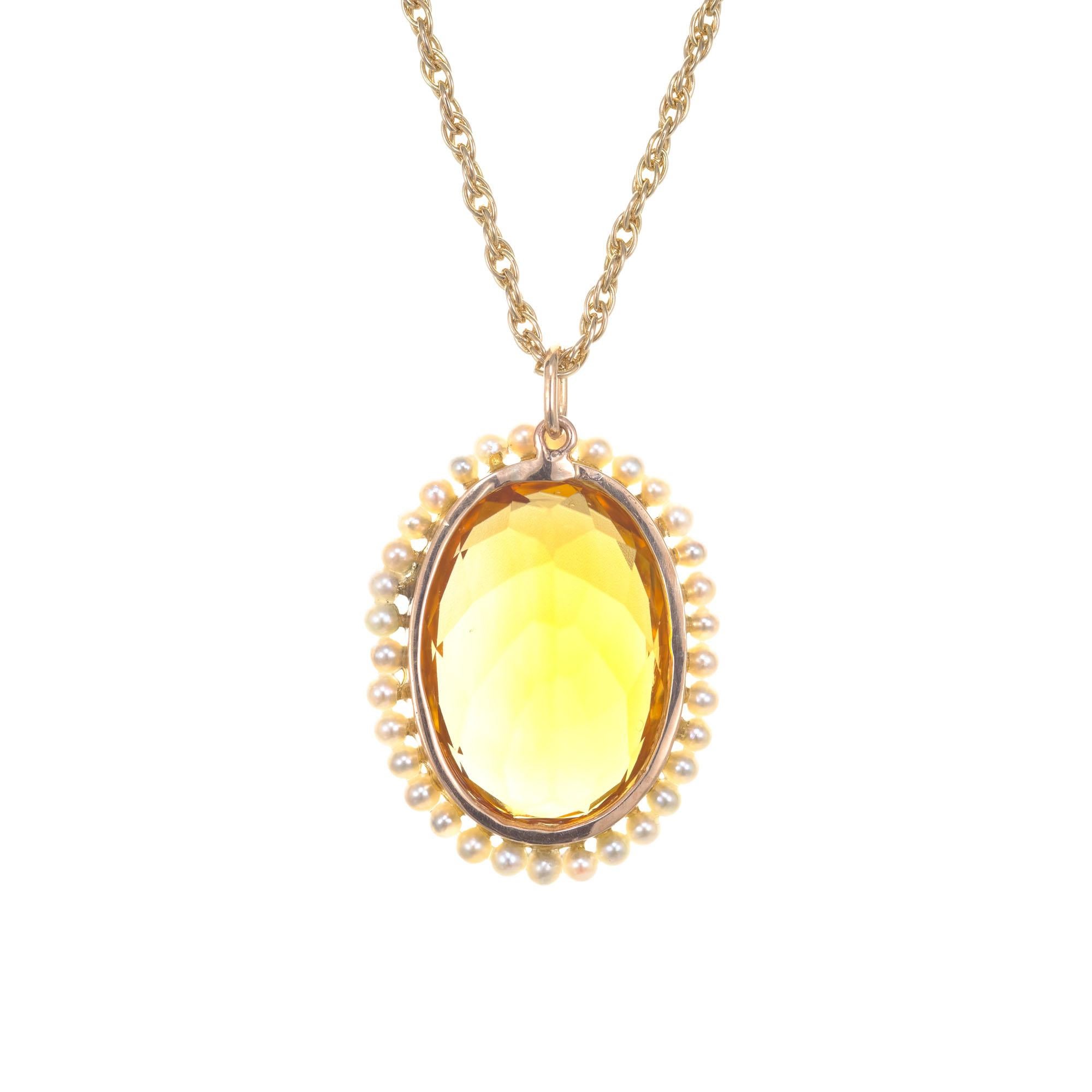 Vintage 1940's oval citrine and pearl pendant necklace. 12.00ct oval citrine in 14k yellow gold with a halo of cultured pearls on a 21 inch chain. 

1 oval orange citrine, approx. 12cts
33 white with gray overtones cultured pearls
14k yellow gold
