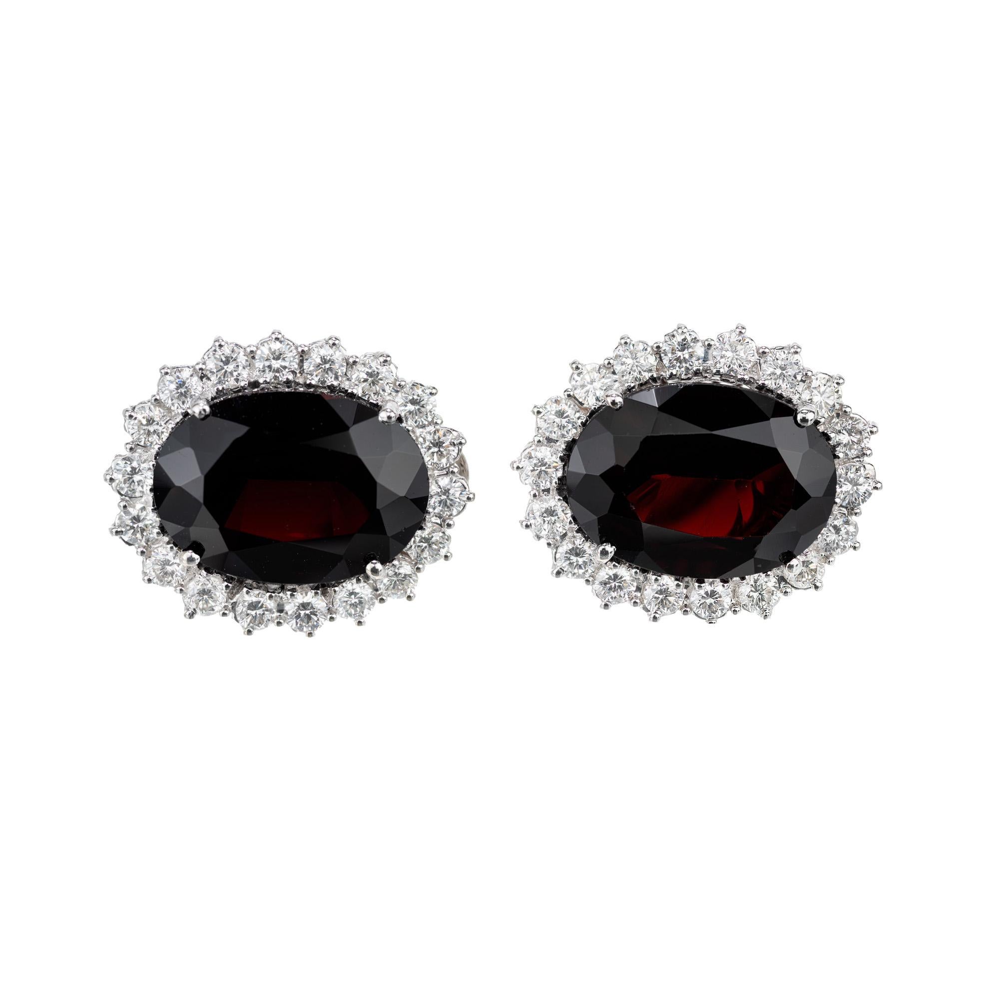Richly deep reddish and brown garnet and diamond earrings. 2 Oval cut garnets totaling 12.00cts set in 18k white gold clip post settings both with 1.62cts of round brilliant cut diamond halos.

2 oval brownish red garnets, approx. 12.00cts
36 round