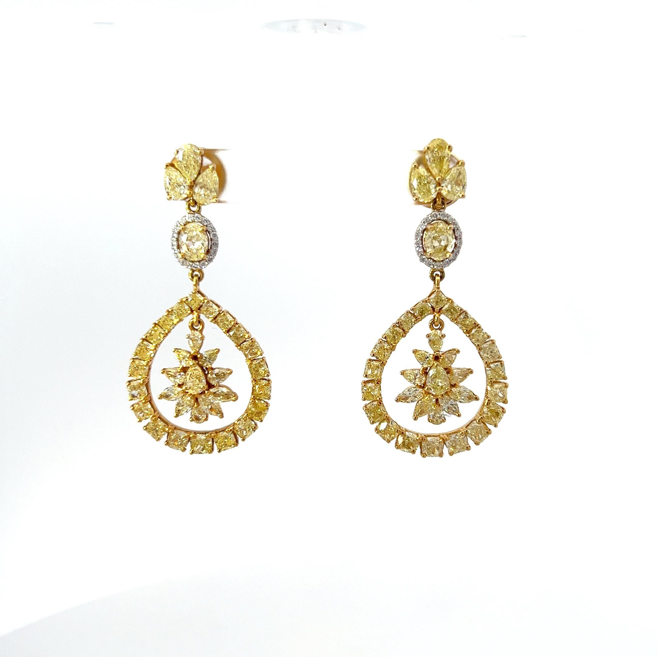 Indulge in the splendor of these enchanting earrings, a true celebration of luxury and artistic finesse. Crafted in 18K yellow gold, each earring features an exquisite array of fancy yellow diamonds, totaling an astounding 11.45 carats. These rare