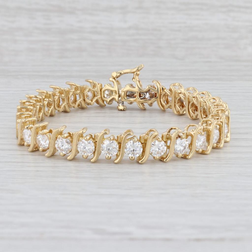 Gem: Moissanite - 12.07 Total Carats, Round Brilliant Cut, Clear / White Color
Metal: 18k White Gold
Weight: 37 Grams 
Stamps: 18k
Style: Tennis Bracelet
Closure: Slide & Latch Clasp
Inner Circumference: 7