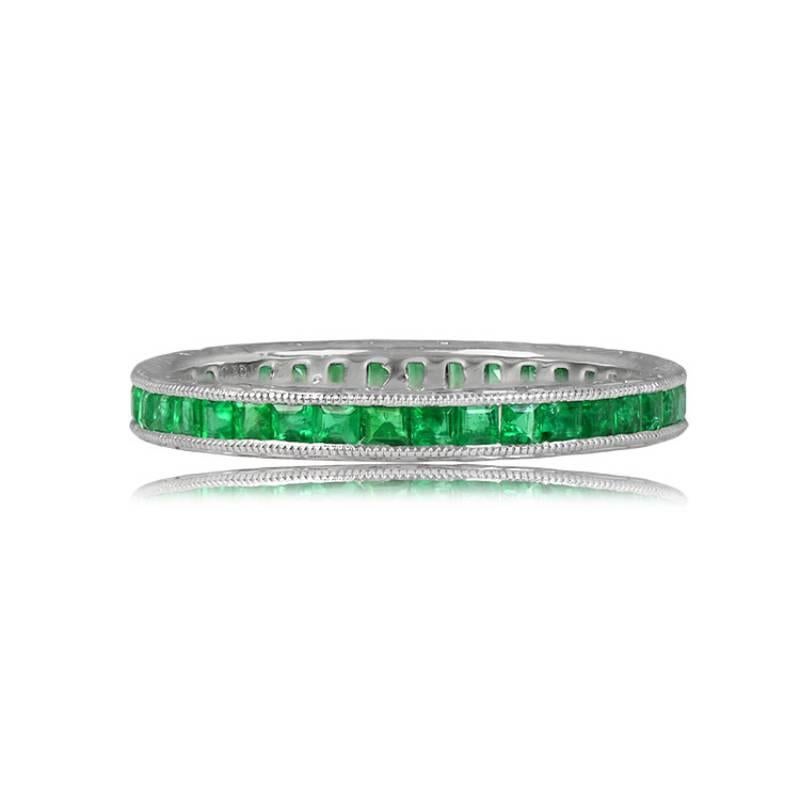 An exquisite wedding band with a perpetual row of calibre-cut green natural emeralds, elegantly channel-set in a meticulously handcrafted platinum setting. The emeralds are delicately framed by fine milgrain detailing, and the band's sides are
