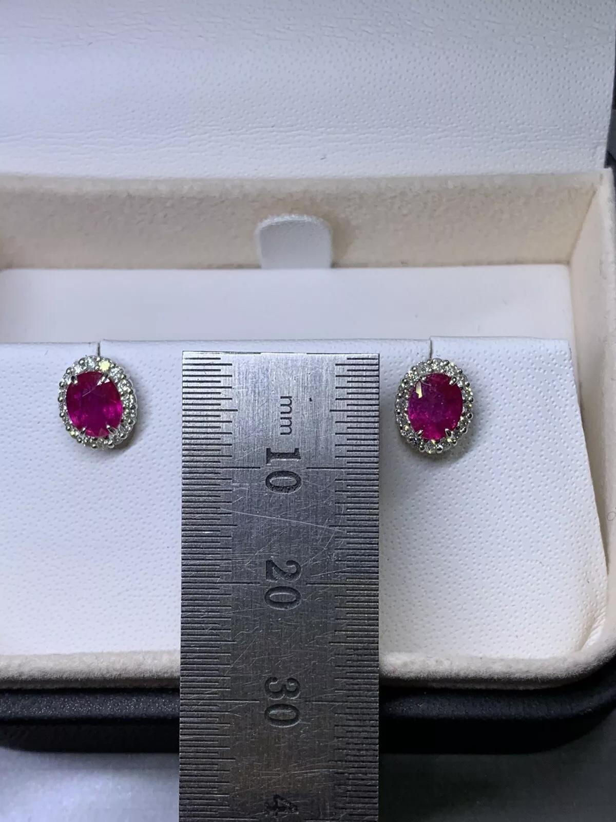 1.20ct Diamonds and oval ruby halo stud earrings in 18k white gold.

Ruby natural unheated oval shape total weight 0.80ct.

Pink intense vivid ruby gemstone oval shaped with diamonds studs earrings.

Diamonds total weight 0.40ct G colour VS1