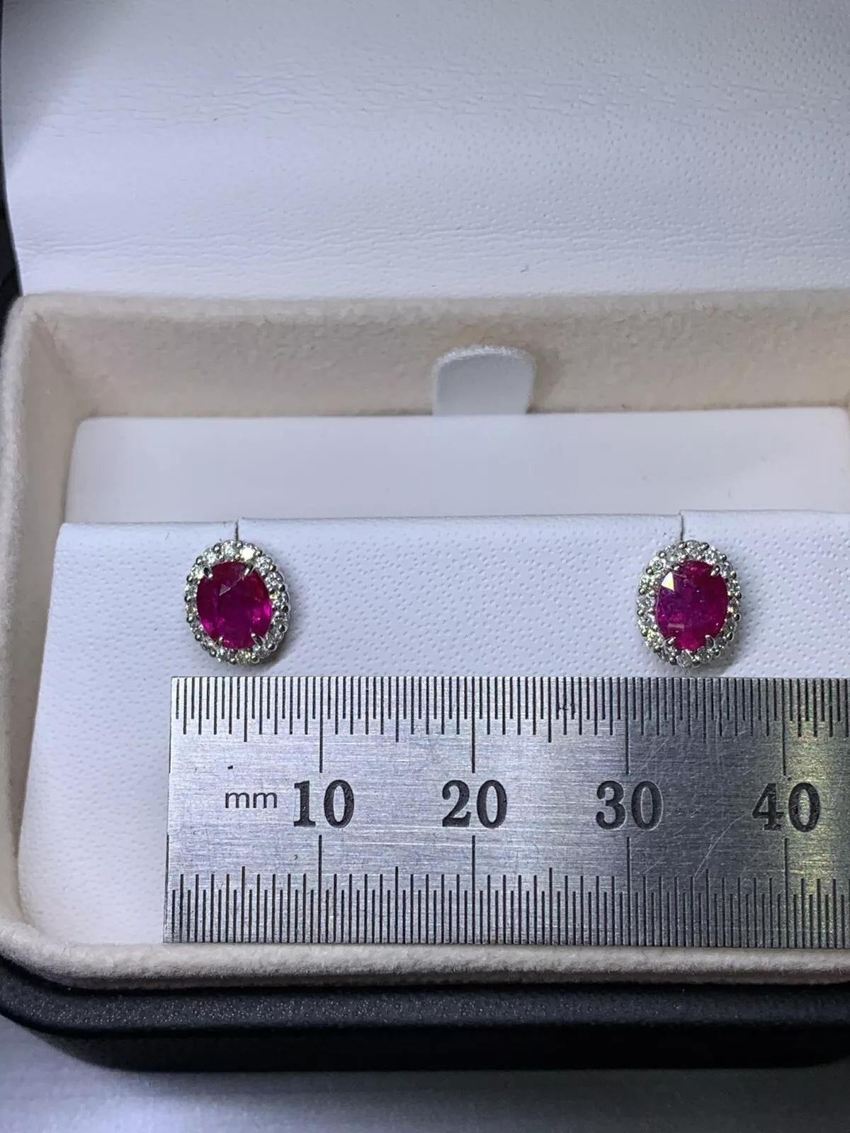 1.20ct Diamonds and oval ruby halo stud earrings in 18k white gold. For Sale 1