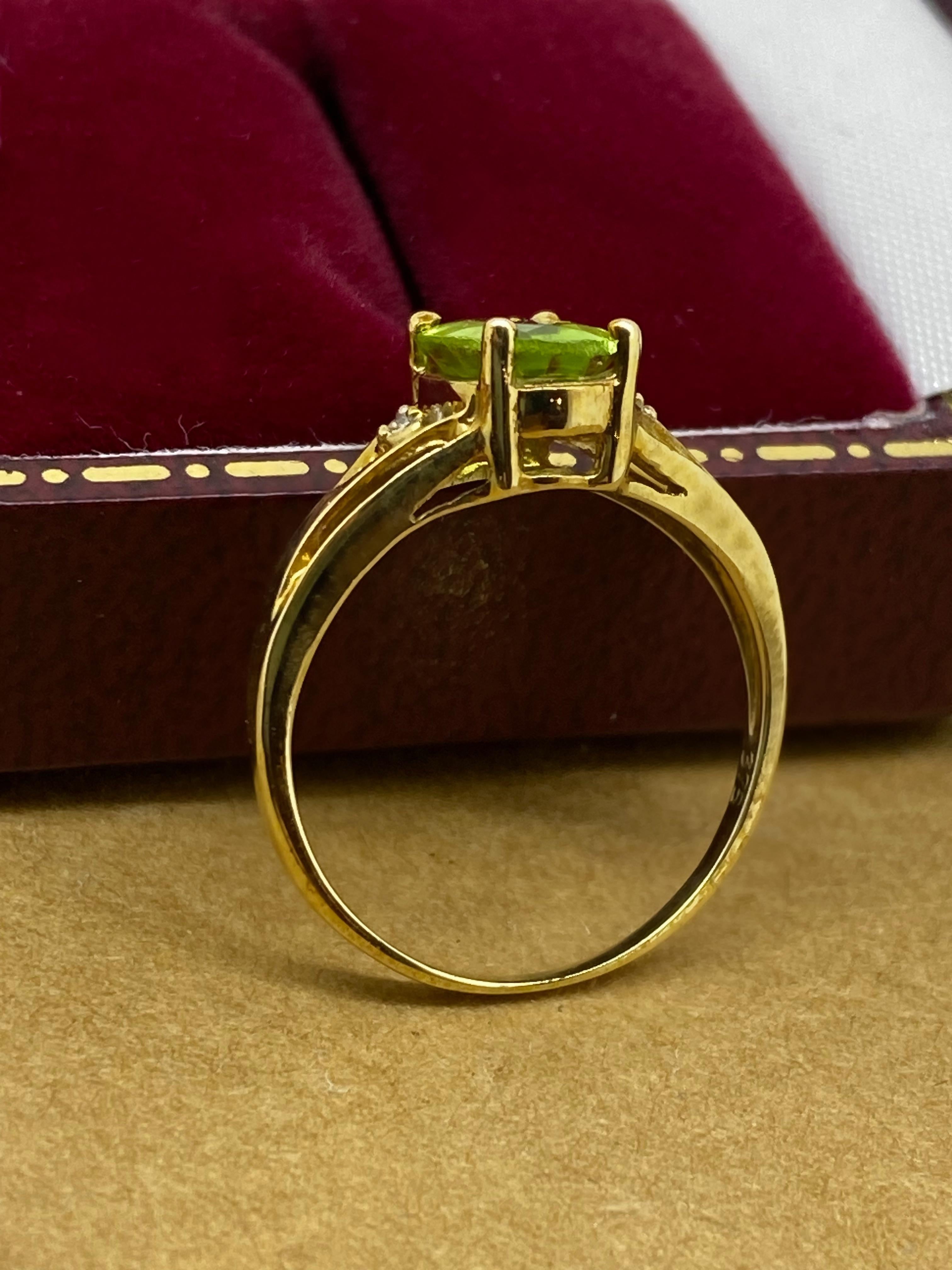 Of an exquisite timeless design, this vintage dress ring 
is set with an oval Natural Peridot 
of distinctive olive-green colour, 
of oval shape, prong set, of 1.20ct approx.

Flanked by 2 small sparkles – diamonds of 0.05ct approx.

The ring is
