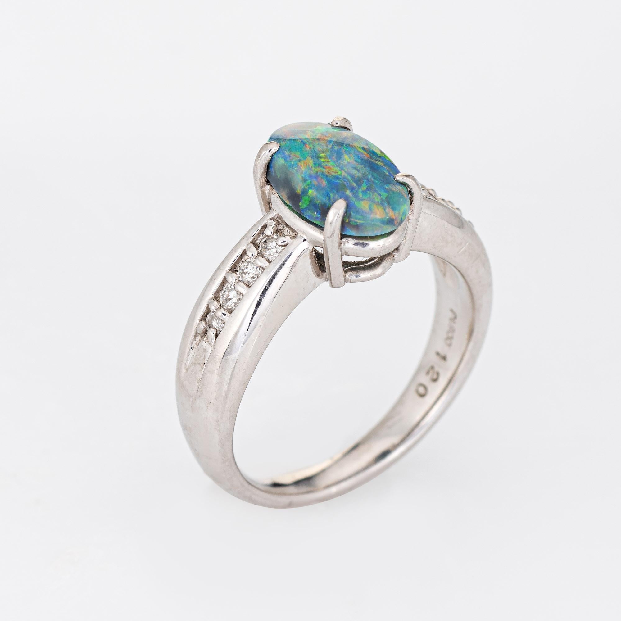 Stylish natural semi-black opal & diamond ring (circa 2000s) crafted in platinum. 

Natural opal measures 10mm x 7mm (estimated at 1.20 carats) is accented with 0.17 carats of diamonds (estimated at H-I color and VS2-SI1 clarity). The opal is in