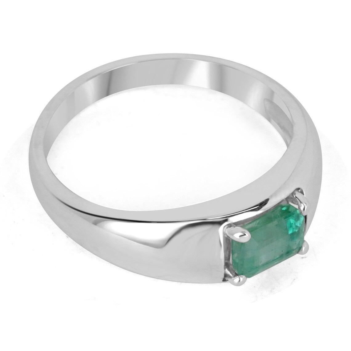 A dapper natural emerald-emerald cut solitaire ring. This exquisite piece features a gorgeous emerald cut emerald from the mines of Zambia. The gemstone showcases a beautiful shine, mossy medium green color, and very good luster. Four-prong set in a