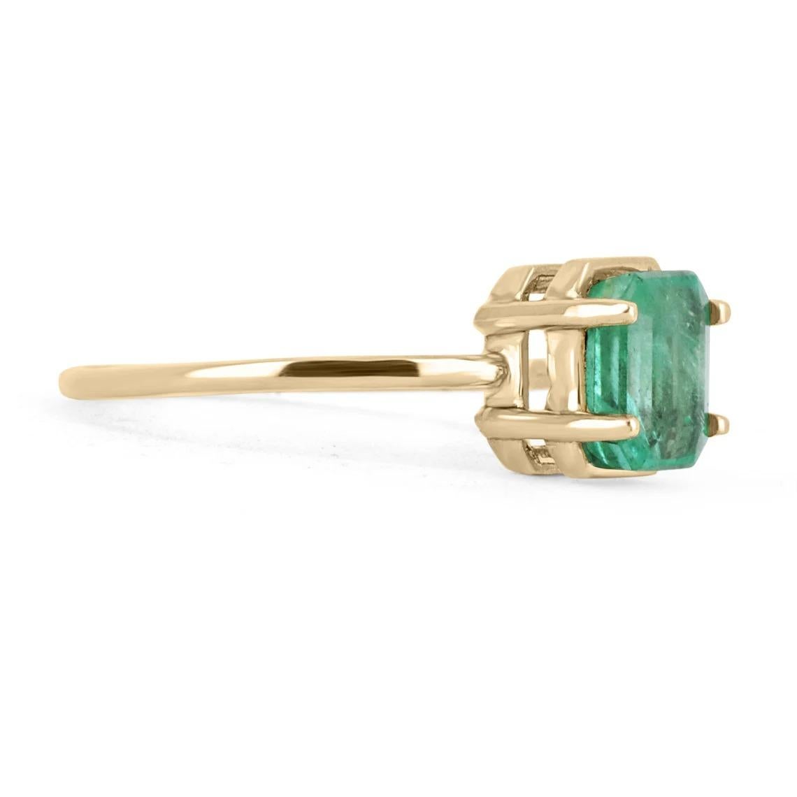 Displayed is a custom emerald solitaire emerald-cut ring in 14K yellow gold. This gorgeous solitaire ring carries a 1.20-carat emerald in a four-prong setting. The emerald has very good clarity with minor flaws that are normal in all genuine