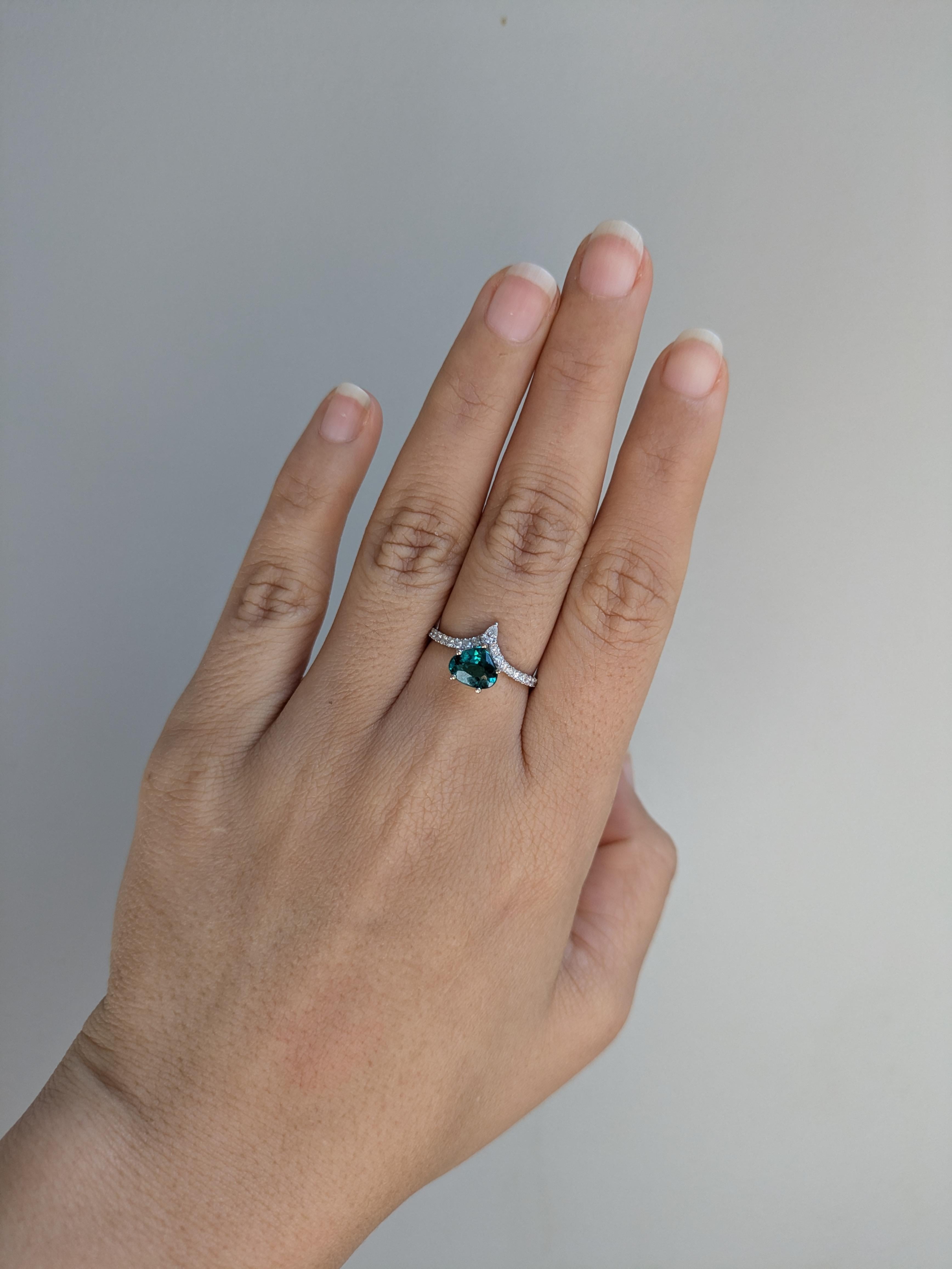 14K White Gold 1.20 Cts Indicolite Tourmaline Diamond Engagement Ring features a striking pear-shaped 7x6mm Indicolite Tourmaline as the centerpiece, surrounded by sparkling diamonds for added elegance. The Indicolite Tourmaline is a beautiful