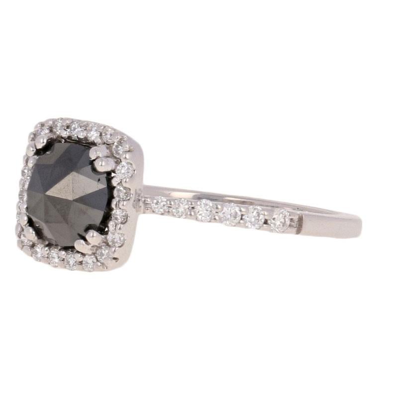 Watch your sweetheart’s eyes sparkle with joy when you propose to her with this stunning engagement piece! Fashioned in 14k white gold, this unique halo ring showcases a majestic rose cut black diamond solitaire beautifully accompanied by glittering