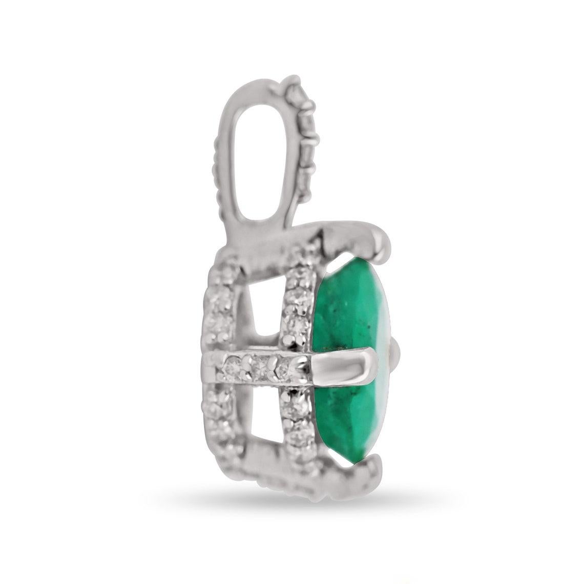 Featured here is a stunning Colombian emerald & hidden diamond halo pendant in fine 14K white gold. Displayed in the center is a natural round emerald accented by brilliant round diamonds. Diamonds highlight the structure of the gold pendant and