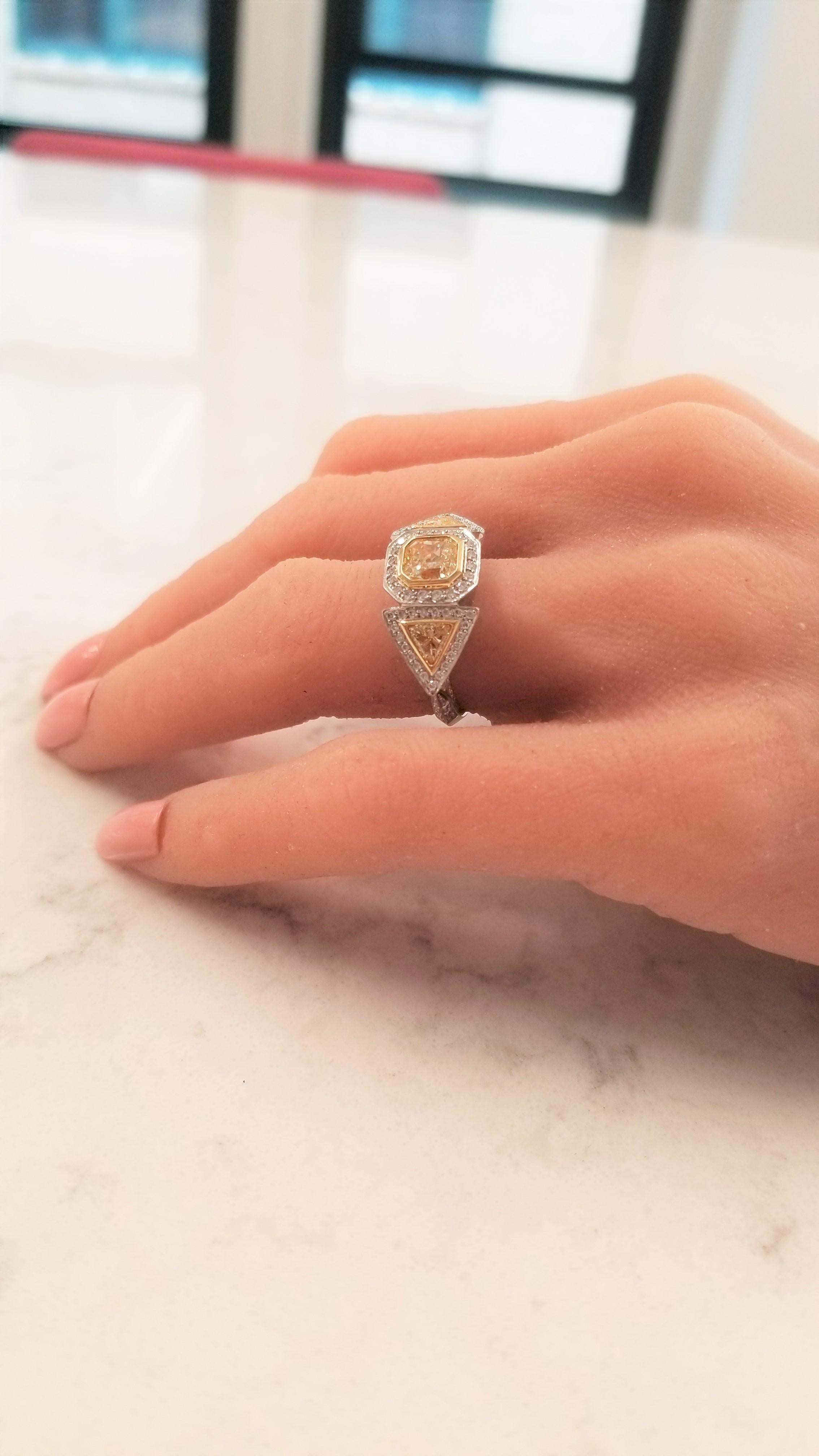 This architecturally inspired ring is spectacular from every angle! The intricate design elements fashioned in platinum and 18 Karat yellow gold add drama and elegance. The illuminating 1.21 Carat square-radiant intense yellow diamond center makes