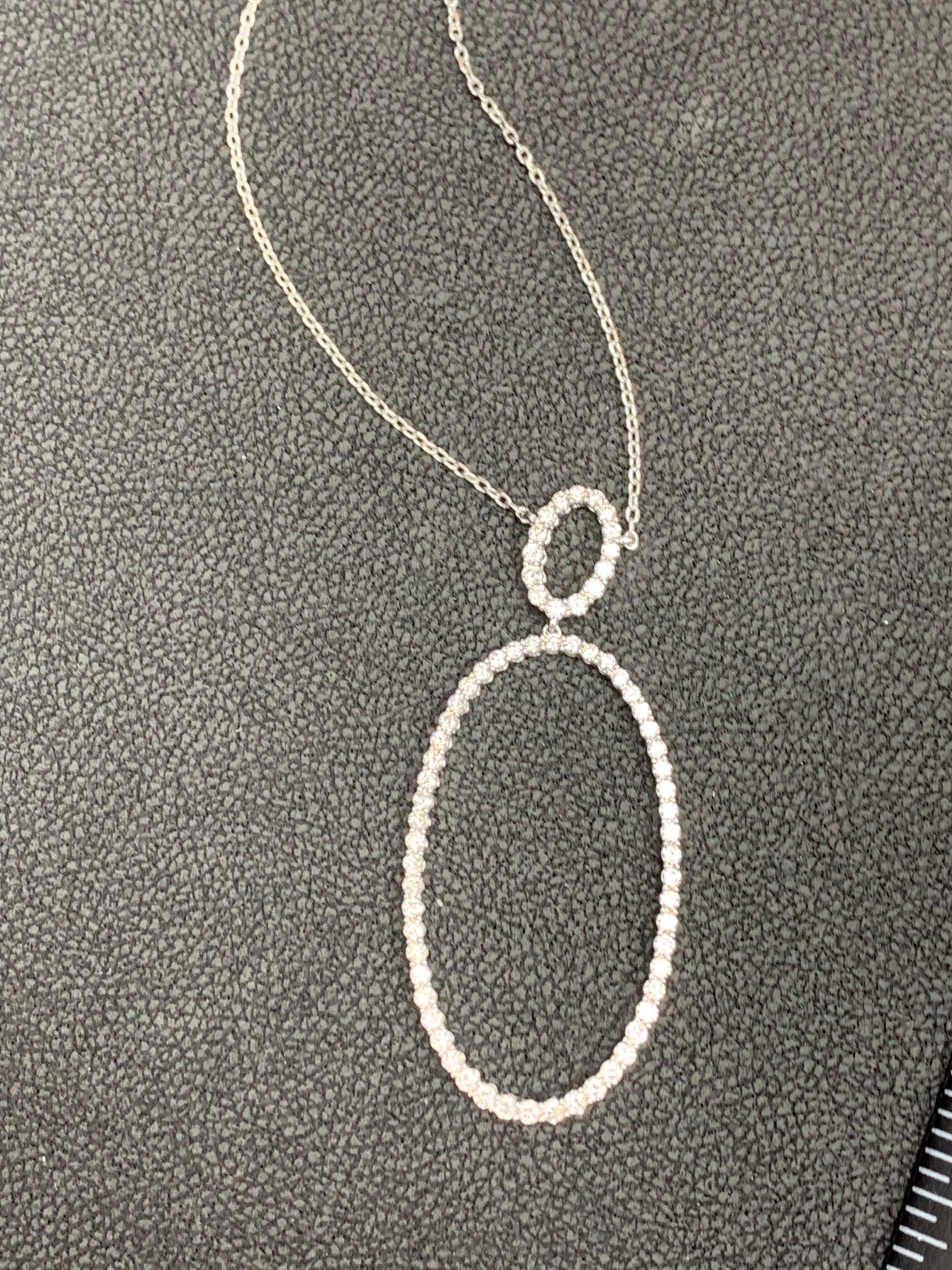 Features an open work oval design pendant accented with round brilliant diamonds. 69 Diamonds weigh 1.21 carats total. Made in platinum. 18 inch chain.