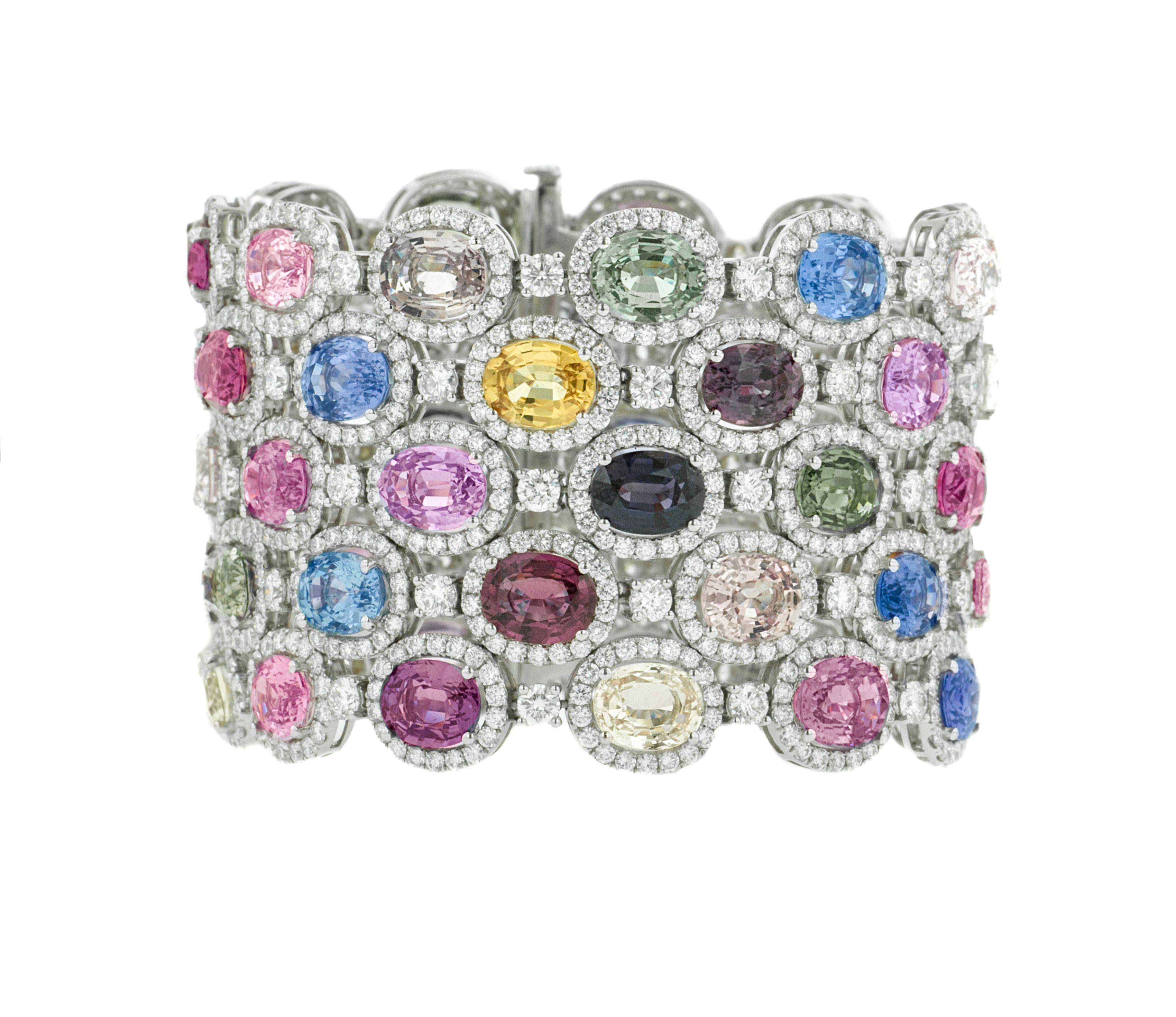  Sapphire and diamond bracelet adorned with 121.00 cts tw of unheated multicolor oval cut sapphires surrounded by 28.50 cts tw of diamonds packed hexagonally in a 18 kt white gold bracelet (VS clarity)