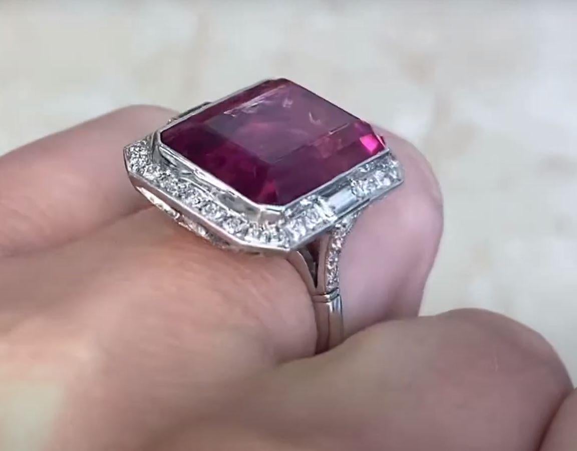 This exquisite ring showcases a striking approx. 12.10-carat emerald-cut rubellite at its center, radiating a rich, vibrant hue. Encircling the rubellite is a luminous halo of old European cut diamonds, meticulously arranged to enhance its