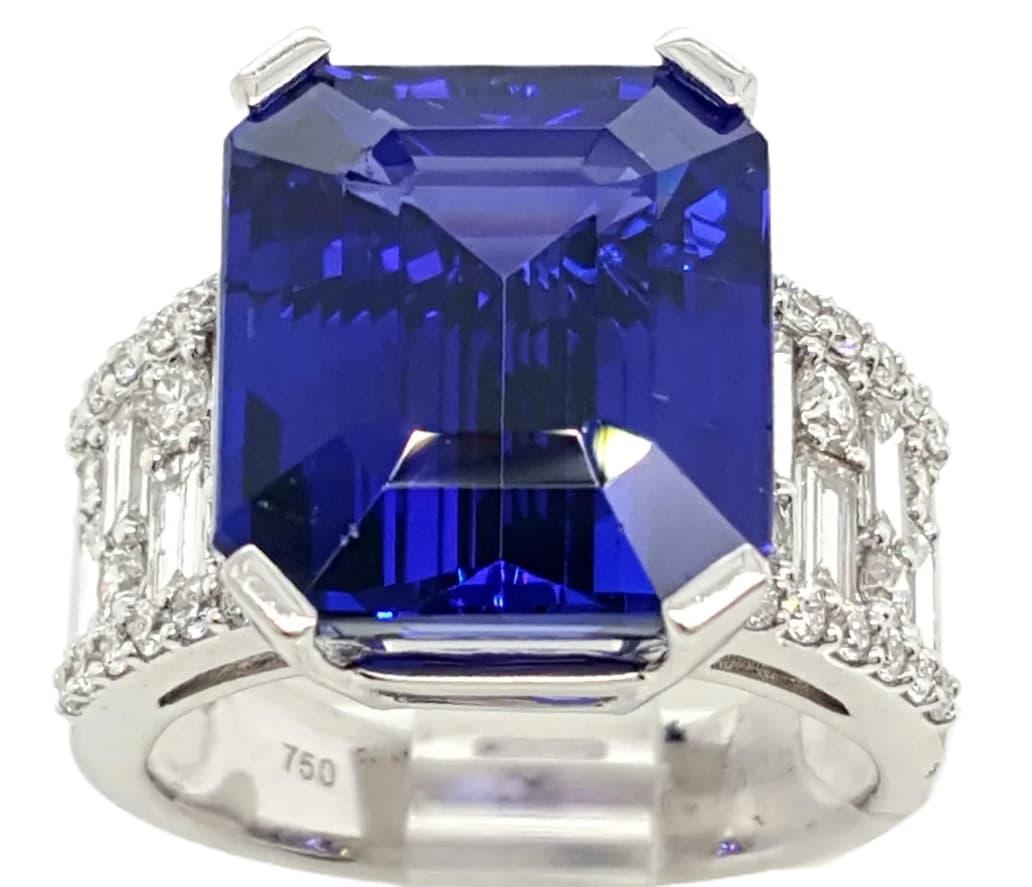 This modern vintage design includes a one of a kind rich emerald cut Tanzanite. The tanzanite has a deeply desired rich color violet, the purplish and blueish color are immediately captivating at first glance. The lavish tanzanite weighs 12.12