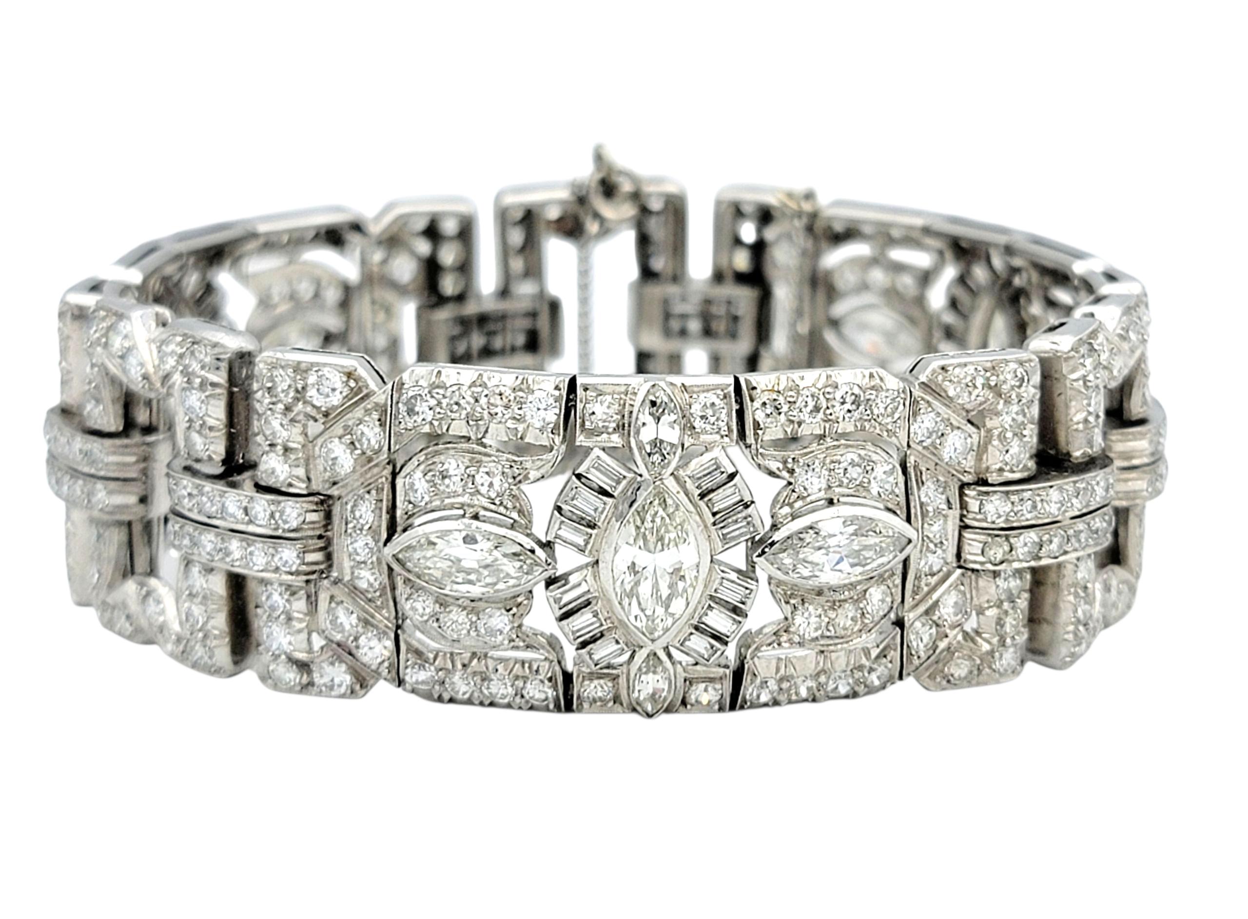 Esta exquisita pulsera de platino encarna la elegancia atemporal de la época Art Déco, con un intrincado diseño geométrico que irradia sofisticación. Hileras de brillantes diamantes meticulosamente dispuestos en talla marquesa, baguette y redonda,