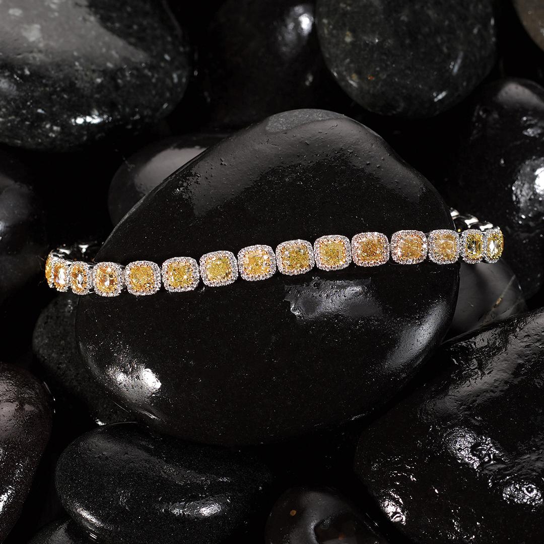 Our striking Matthew Ely Yellow Diamond Bracelet features a selection of 28 timeless Cushion Cut Fancy Yellow Diamonds totalling 12.18cts, surrounded by 412 White Diamonds totalling 1.07cts (color F / G clarity VS) encased in two tones 18ct White