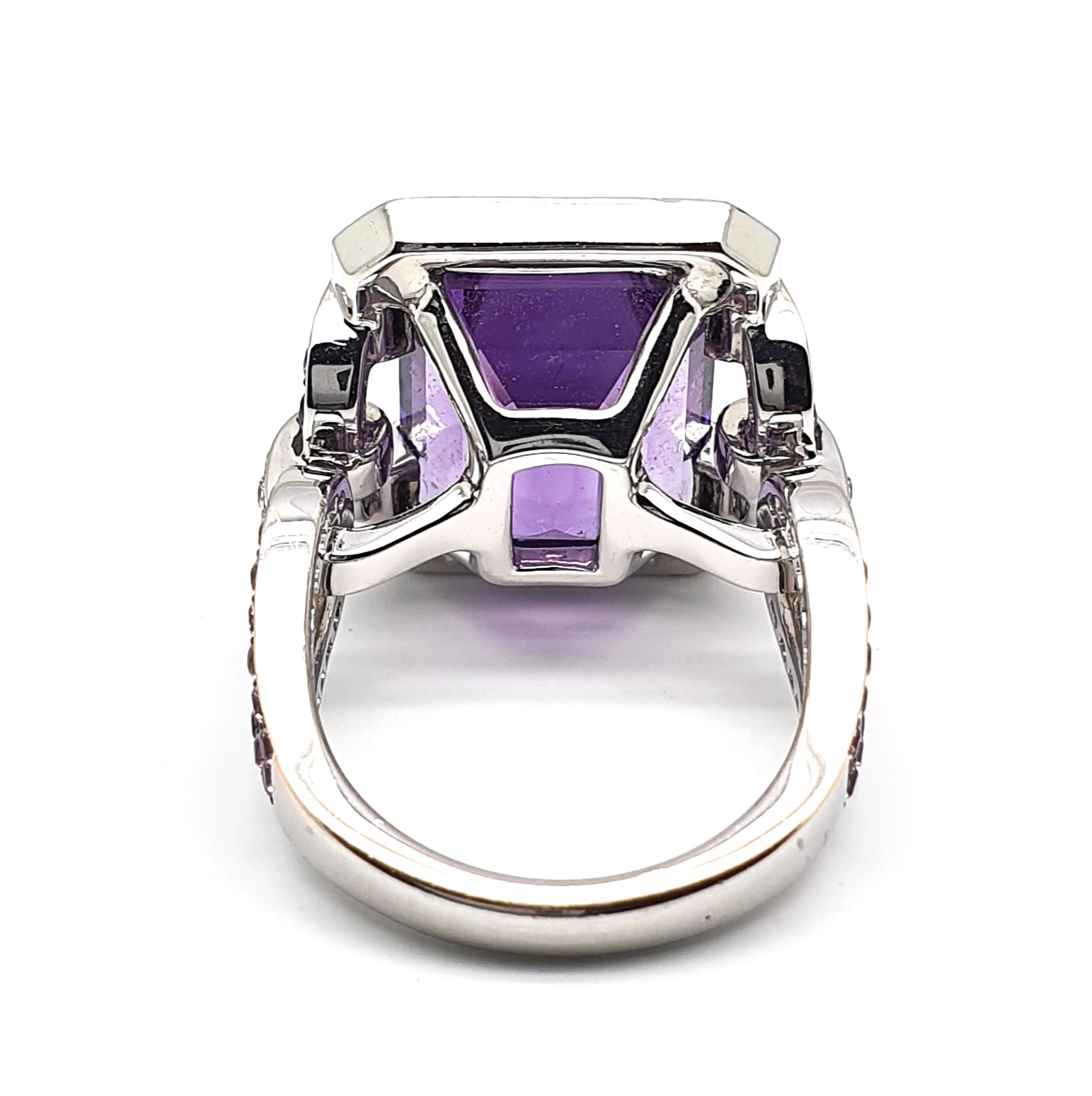 An eyecatching in colour splendid matching 18Krt White Gold ring occupied with 12.18ct an 8-angled cut Amethyst entourage, lilac-blue Corunds, 1.12ct, and 0.28ct brilliantly cut diamonds, colour W and clarity VVSi combined with pink Corunds