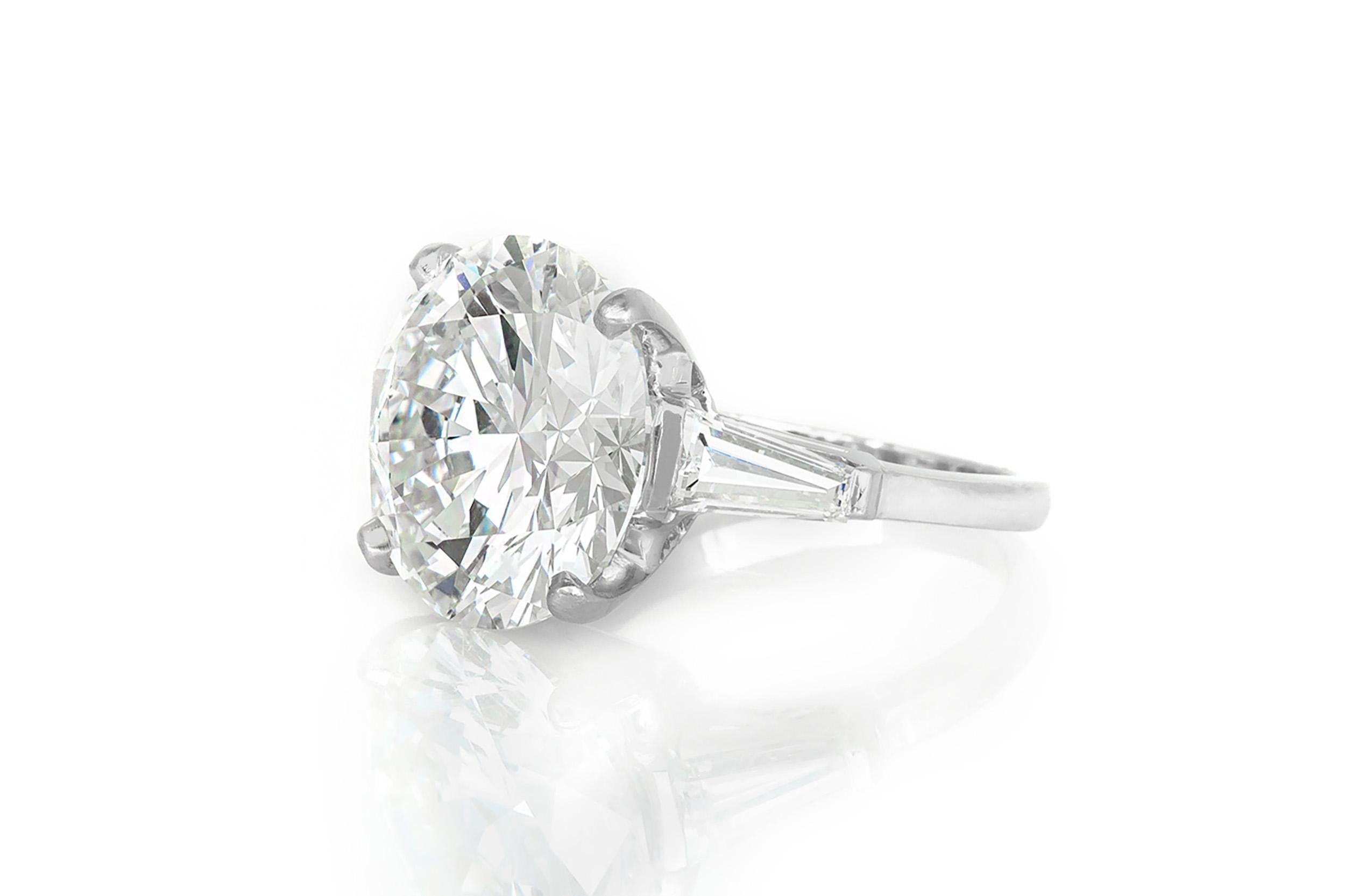 Finement réalisé en platine avec un diamant rond certifié GIA de taille Brilliante pesant 12,19 carats, couleur I, pureté SI2, GIA #5151262601.
La bague est ornée de deux diamants latéraux de taille baguette effilée.
Taille 6 3/4, redimensionnable
