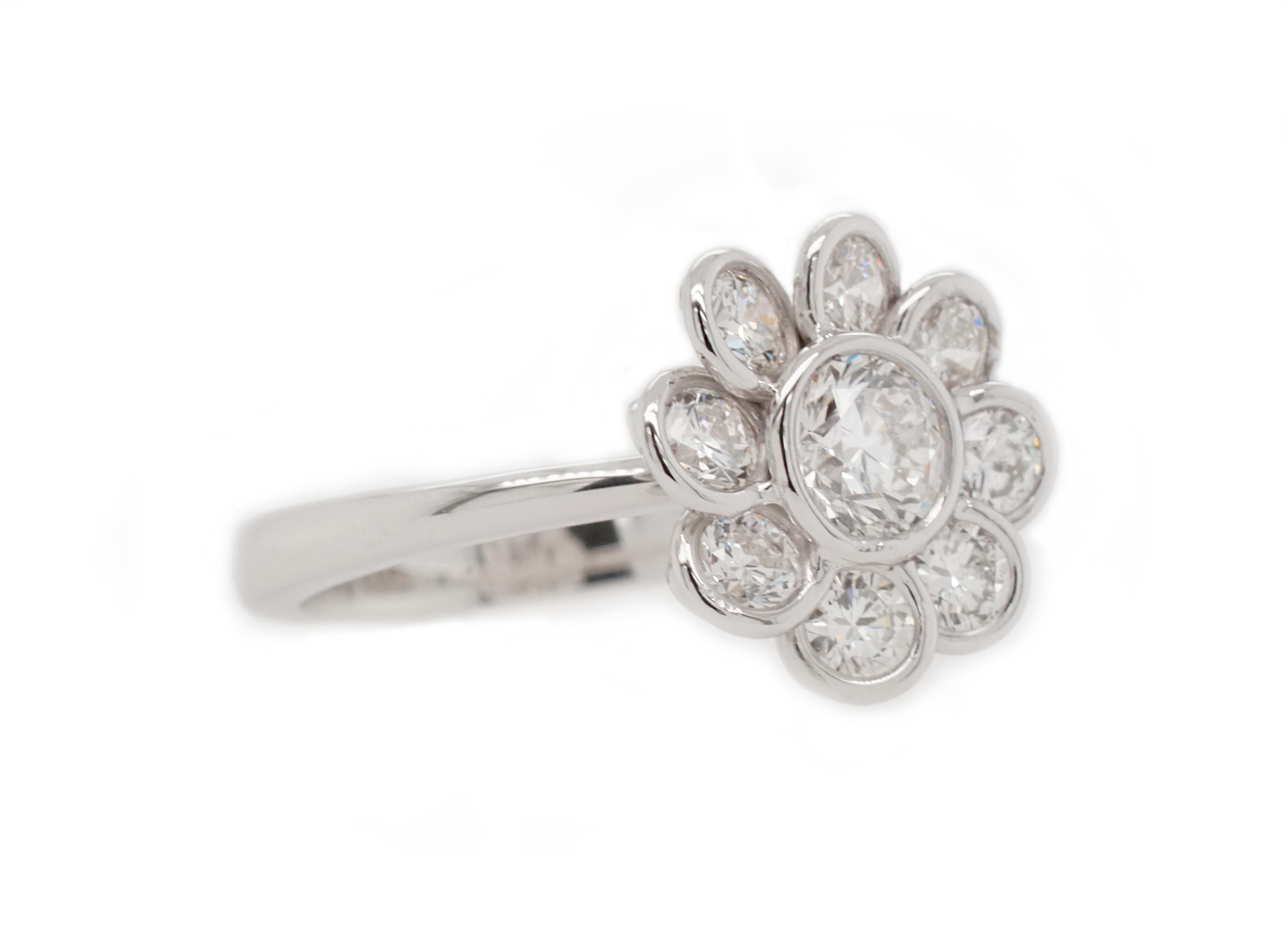 This elegant and poetic ring features 9 bezel-set round brilliant white diamonds in the shape of a flower. 

Set in 14K white gold. 

Center stone: Round brilliant white diamond - 0.50 carat, G color, SI1 clarity. 

Accent stones: Round brilliant