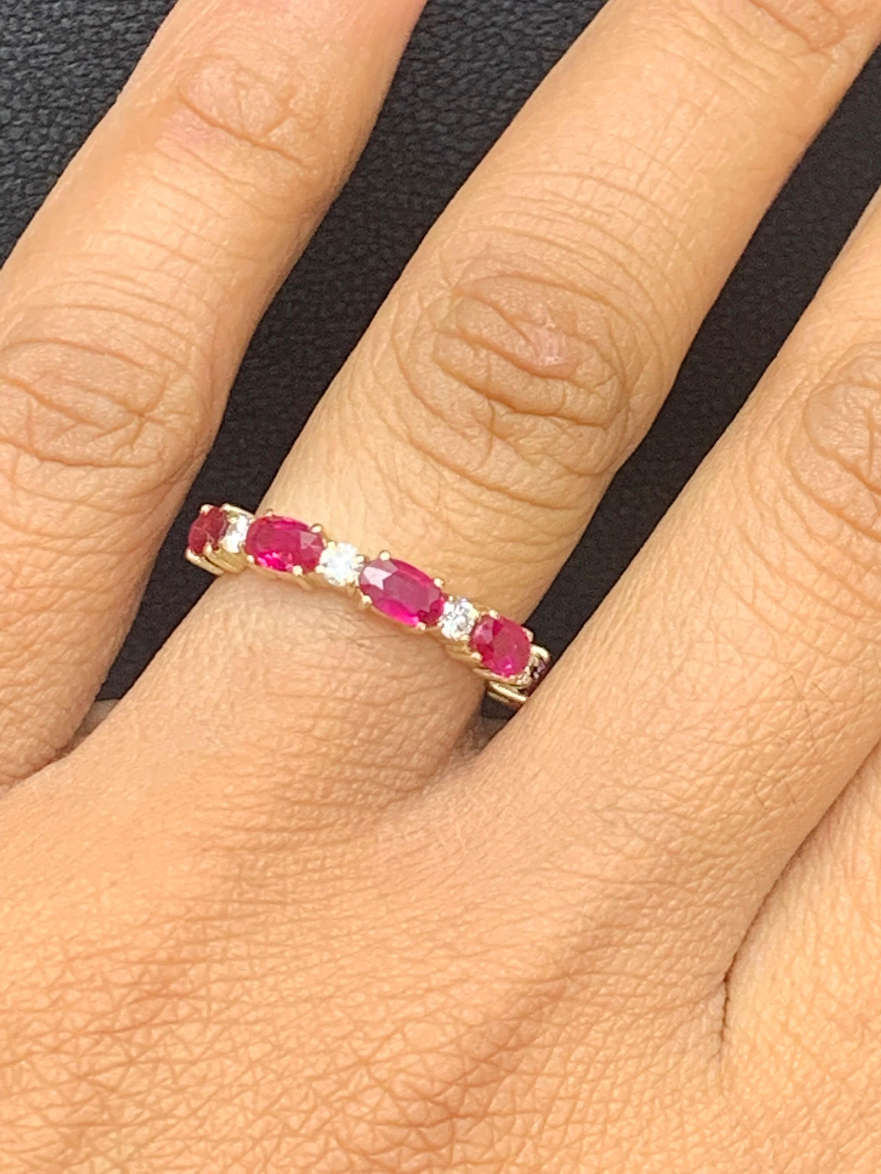 A unique and fashionable wedding band style showcasing 5 Oval Cut Ruby spaced by brilliant-cut diamonds, set in a shared-prong open gallery mounting made in 14k yellow gold. Ruby weighs 1.22 carats total; diamonds weigh 0.20 carats total. Size 6.5