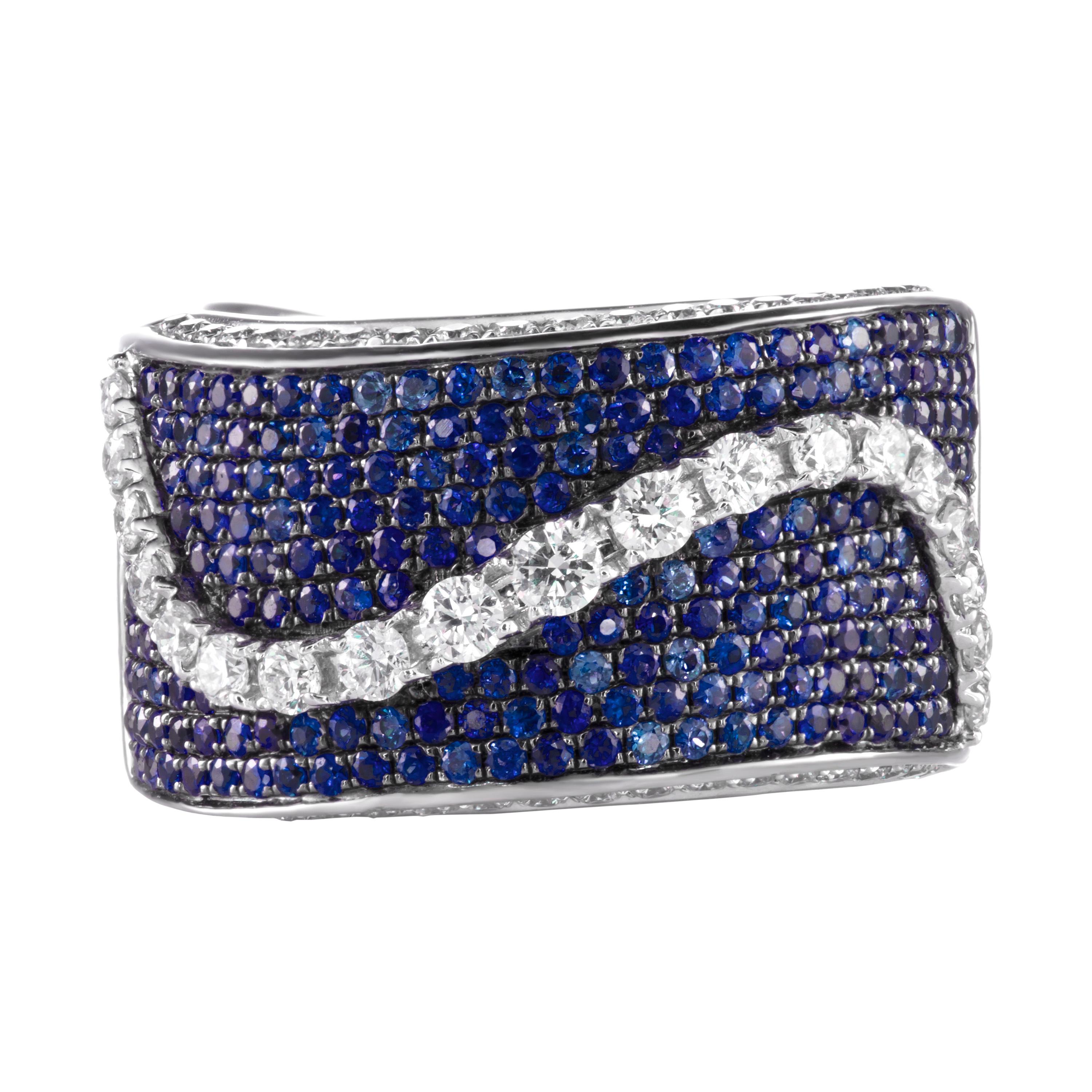A beautifully crafted band ring with 1.22 carats of royal blue sapphires and a center wave of 0.86 carats of brilliant round diamonds.  Set in 18K white gold.  Currently a ring size US 7.  For other sizes, please contact seller.  Also available in