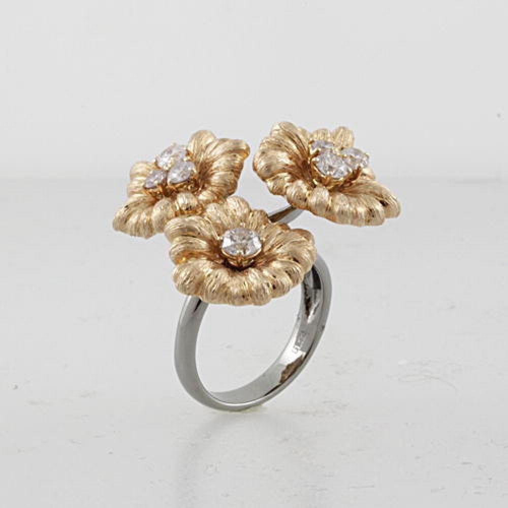 Step into a world of delight and magic with this 1.22 Carat Gold Flower Motif Ring Crafted in 18K Gold. This one of a kind ring features 3 glamorous flowers- two flowers are centered by 3 round cut diamonds and the third is centered by 1 round cut