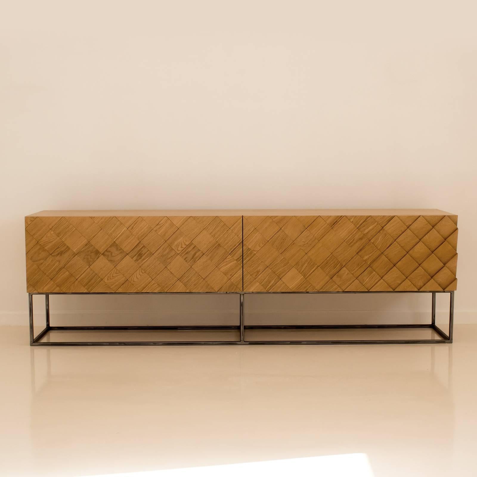 The linear and simple design of this sophisticated sideboard is complemented by the captivating, masterfully handcrafted pattern on the front panels. Composed of 122 pieces of wood, each piece is individually cut, polished, and assembled by hand to