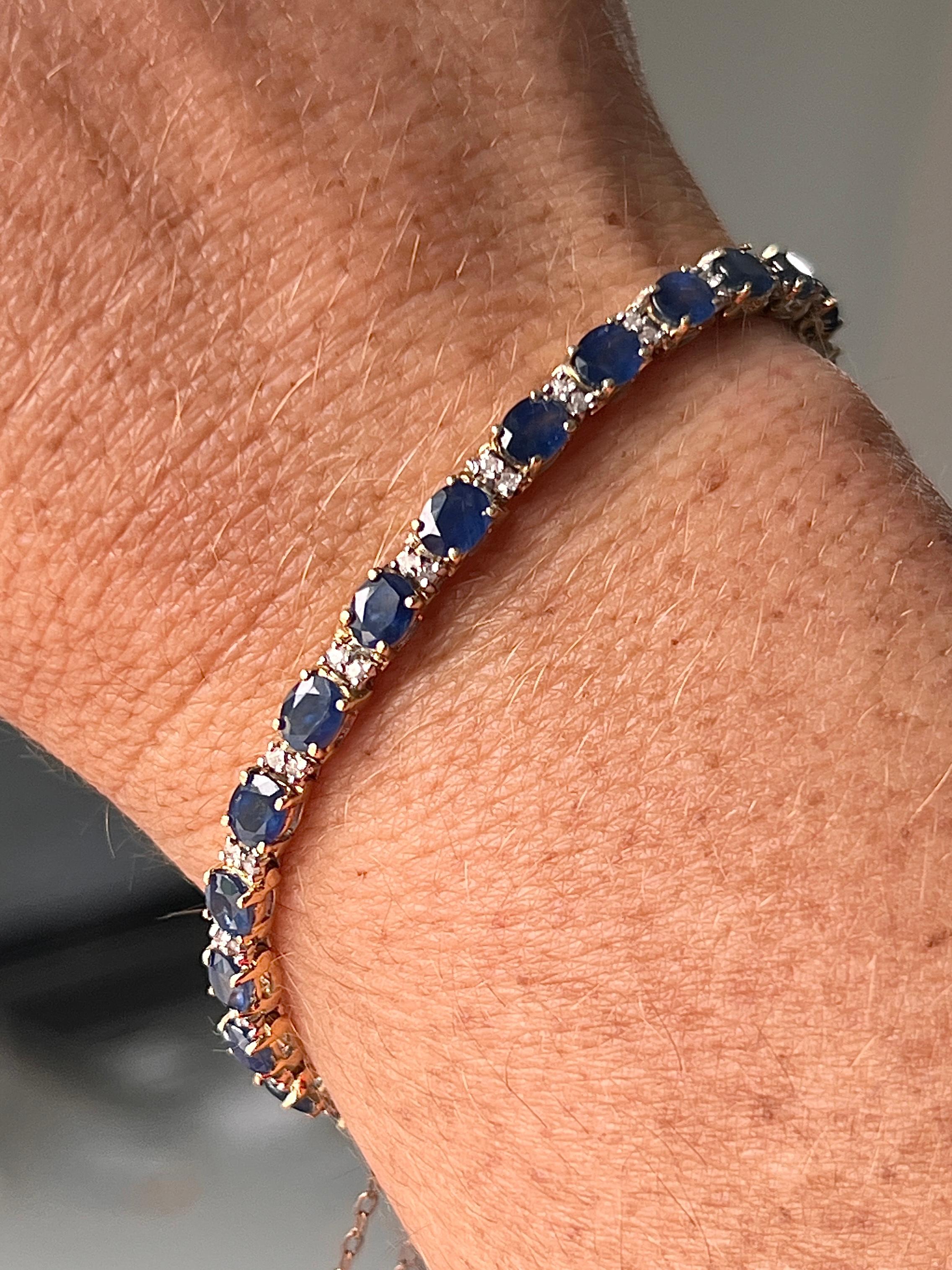 Ce bracelet classique en or jaune 14 carats présente vingt-cinq saphirs bleus ovales d'un poids total approximatif de 12,25 carats, d'une teinte riche et uniforme. Les saphirs sont rehaussés de cinquante diamants ronds de taille unique totalisant
